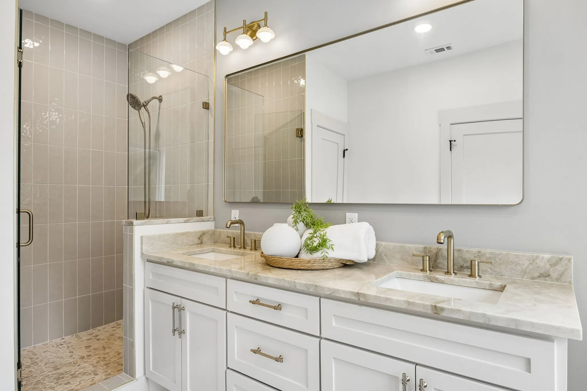 The ensuite bathroom has a separate frameless glass shower.