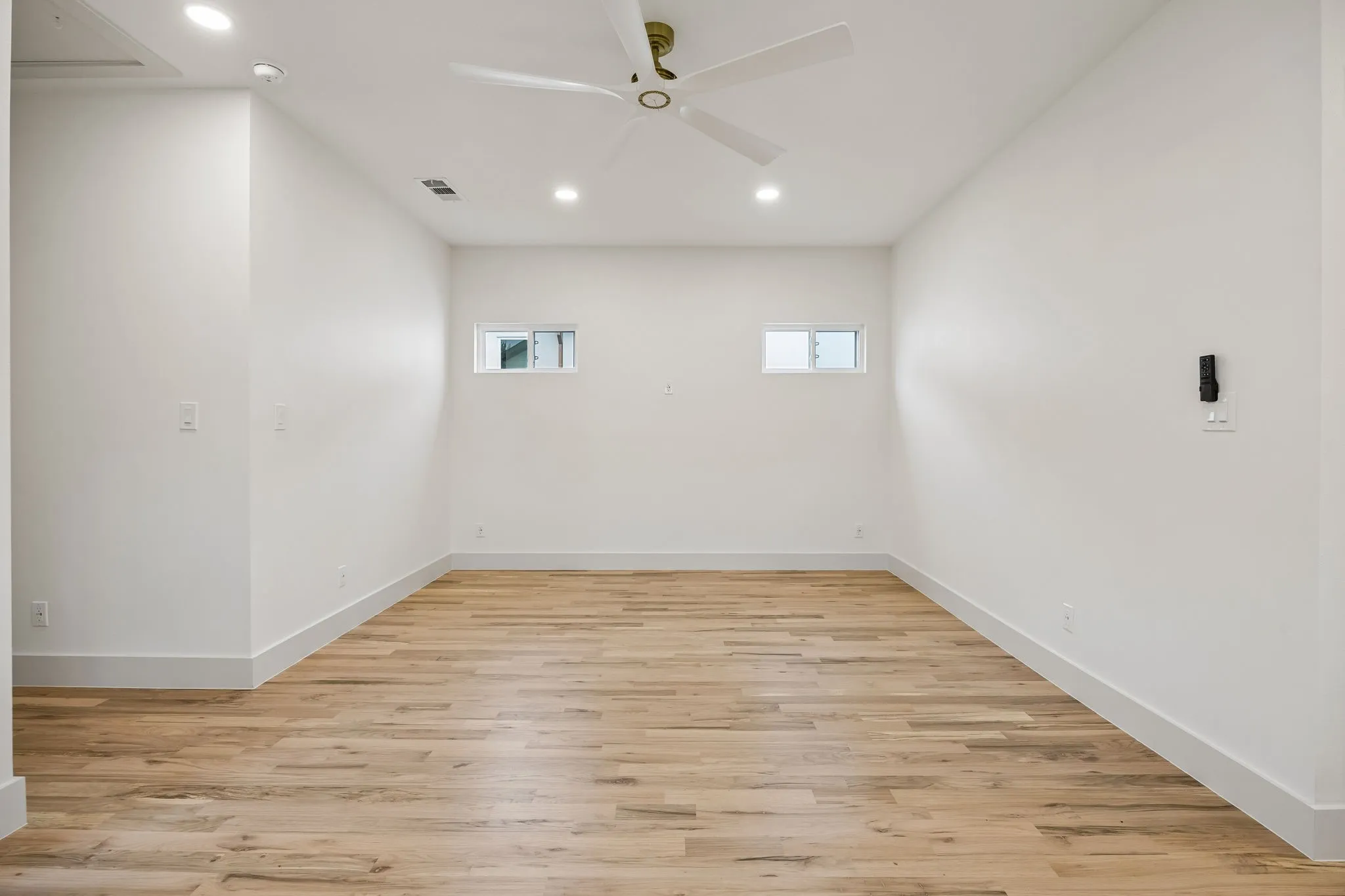 The upstairs family room features a ceiling fan and recessed lighting