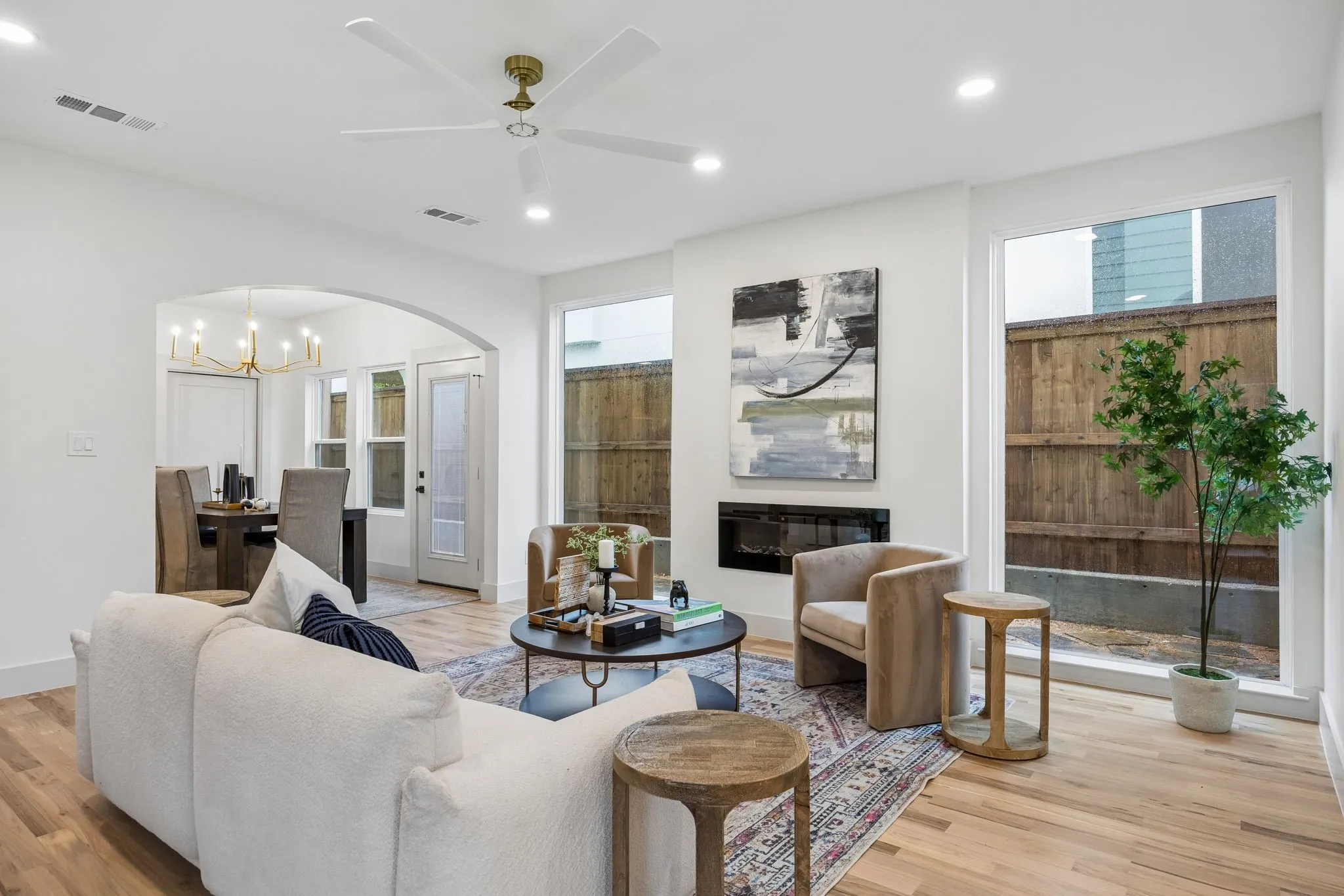 Open-concept living space featuring wood-finish flooring, recessed lighting, and a modern electric fireplace