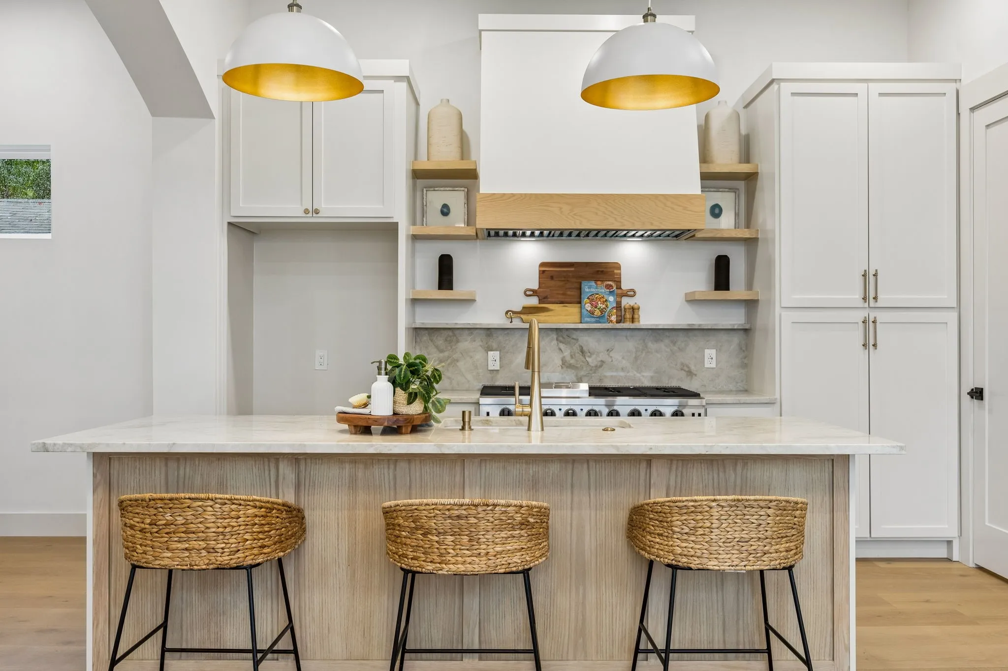 Kitchen island featuring two dome pendant lights with gold interiors