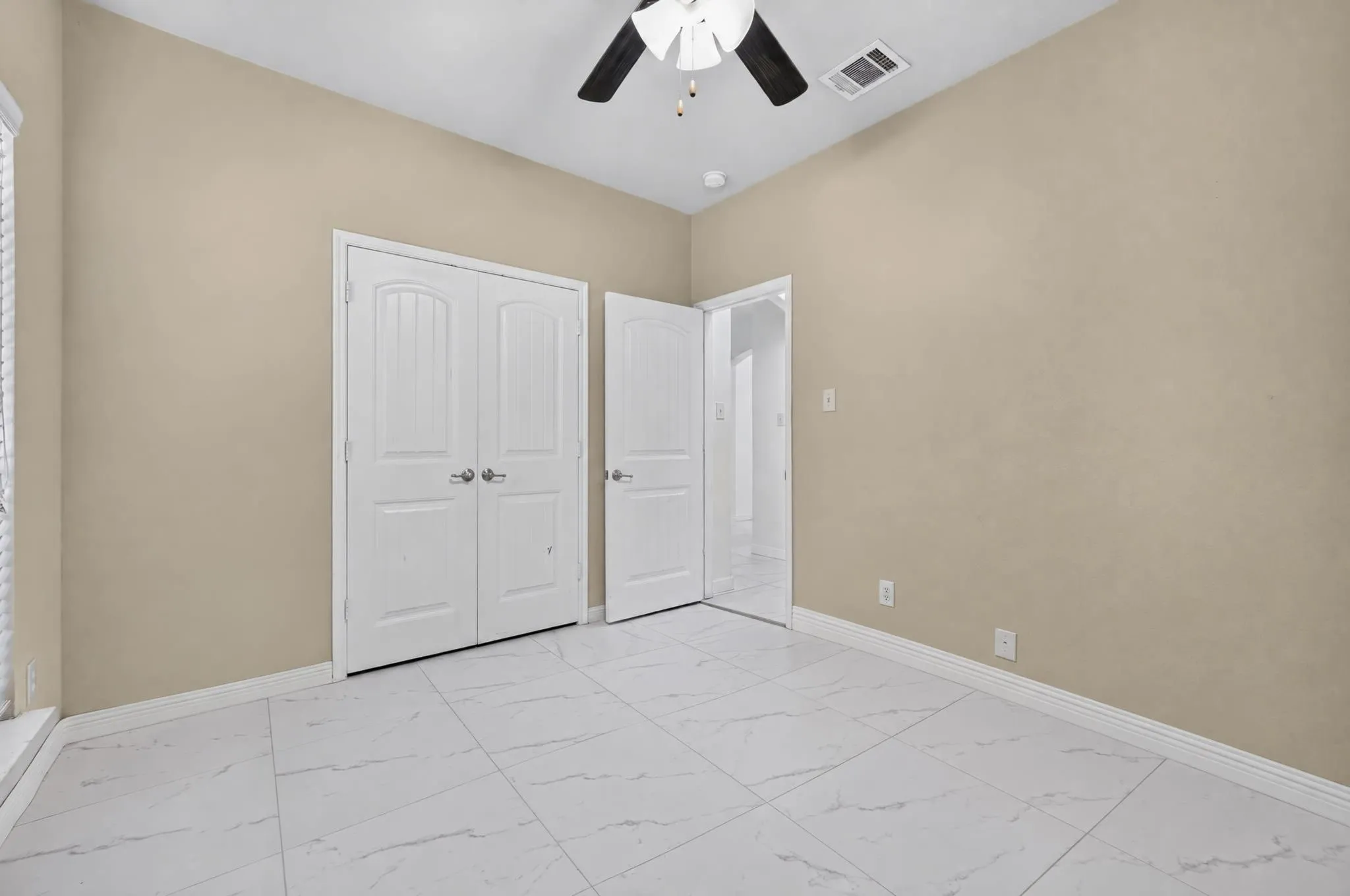 White tile flooring, double panel doors, white trim, ceiling-mounted fan, and recessed lighting