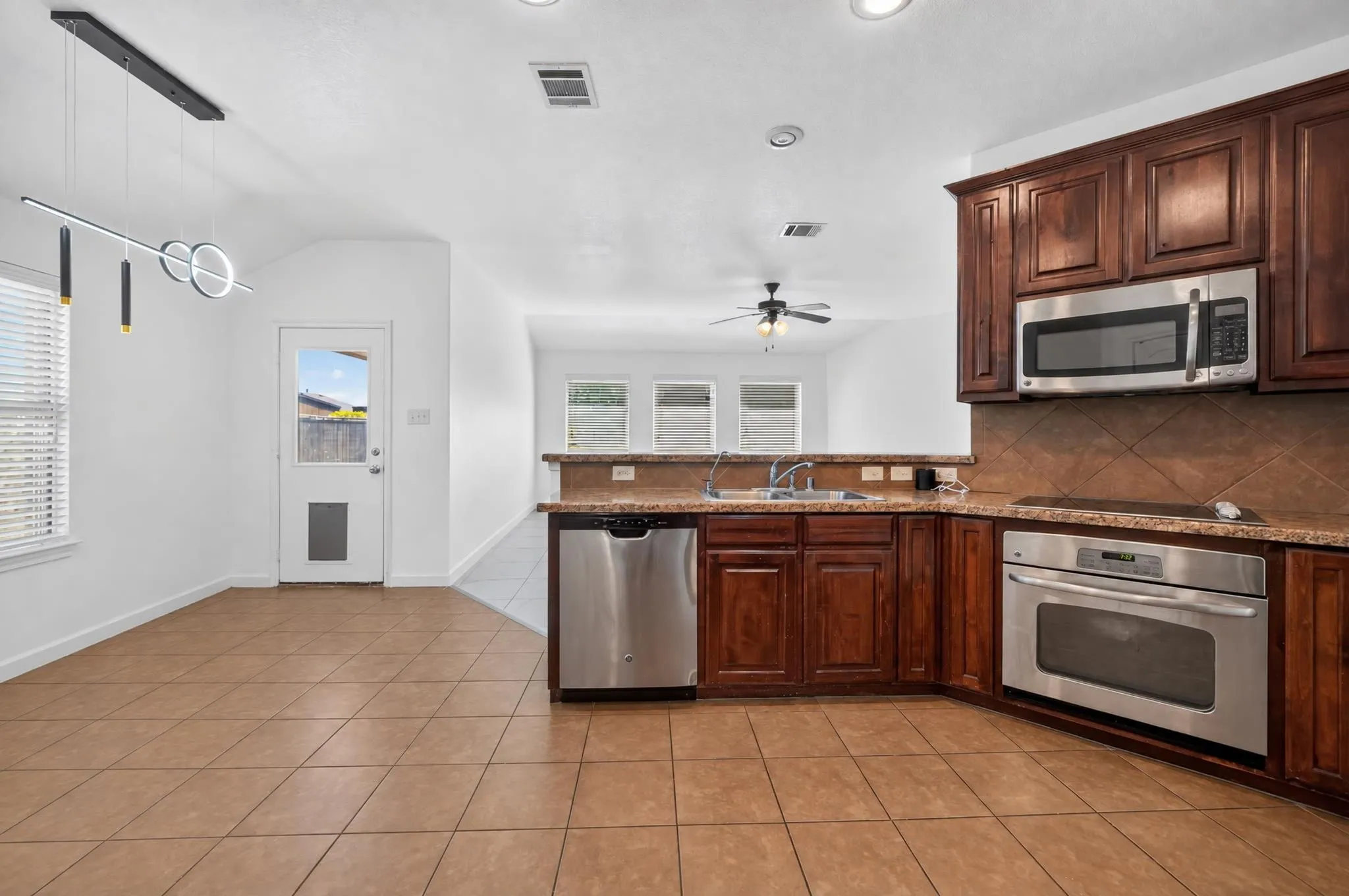 Kitchen featuring wood-finish cabinetry, stainless steel appliances, and a built-in microwave