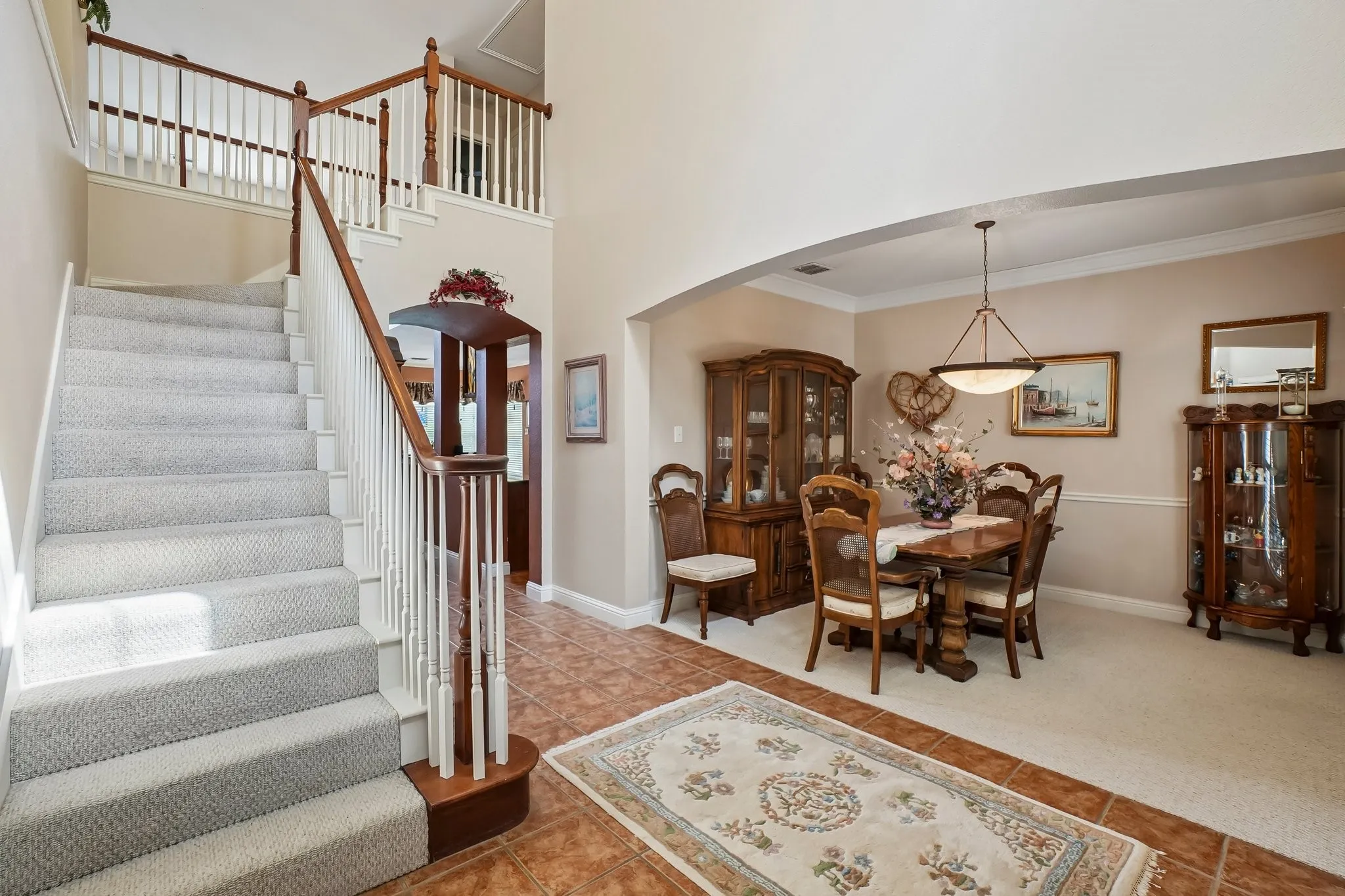 Two-story foyer with a carpeted staircase and wood-finish railing