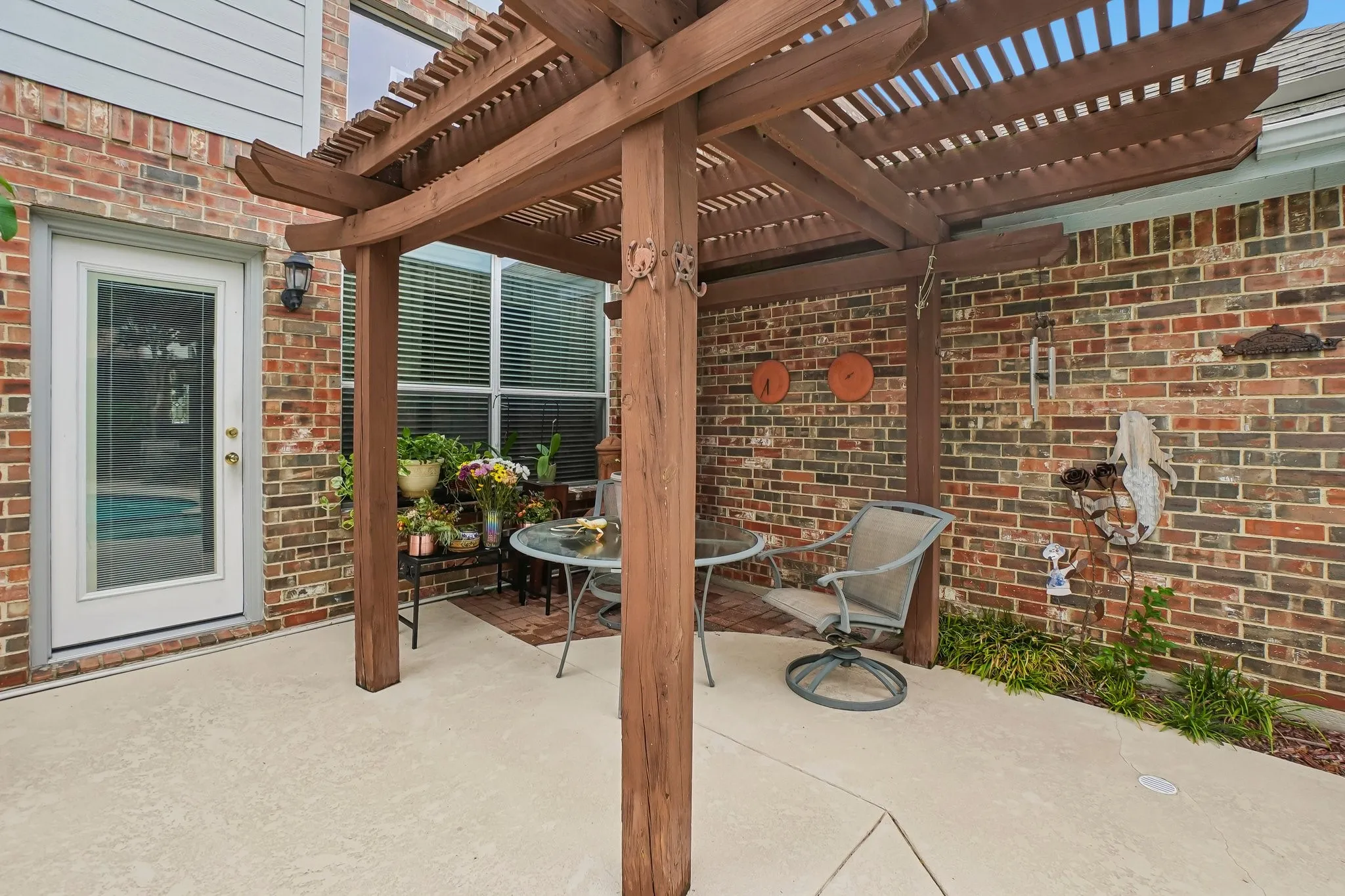 Patio area featuring a wood pergola and brick exterior