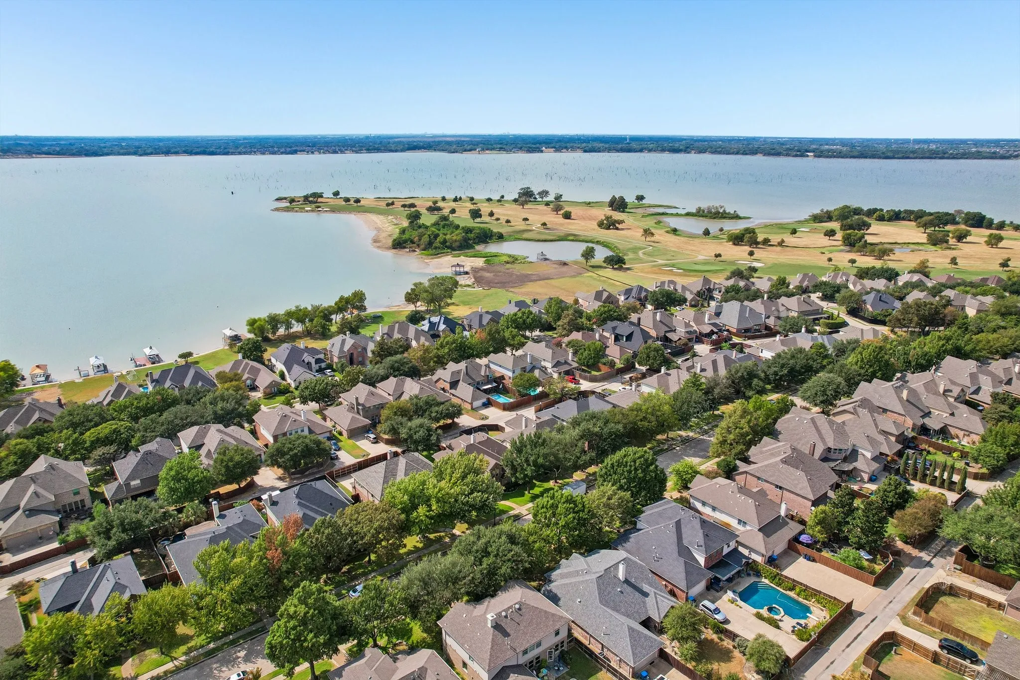 Waterfront community with mature trees, established residential properties, and private swimming pools