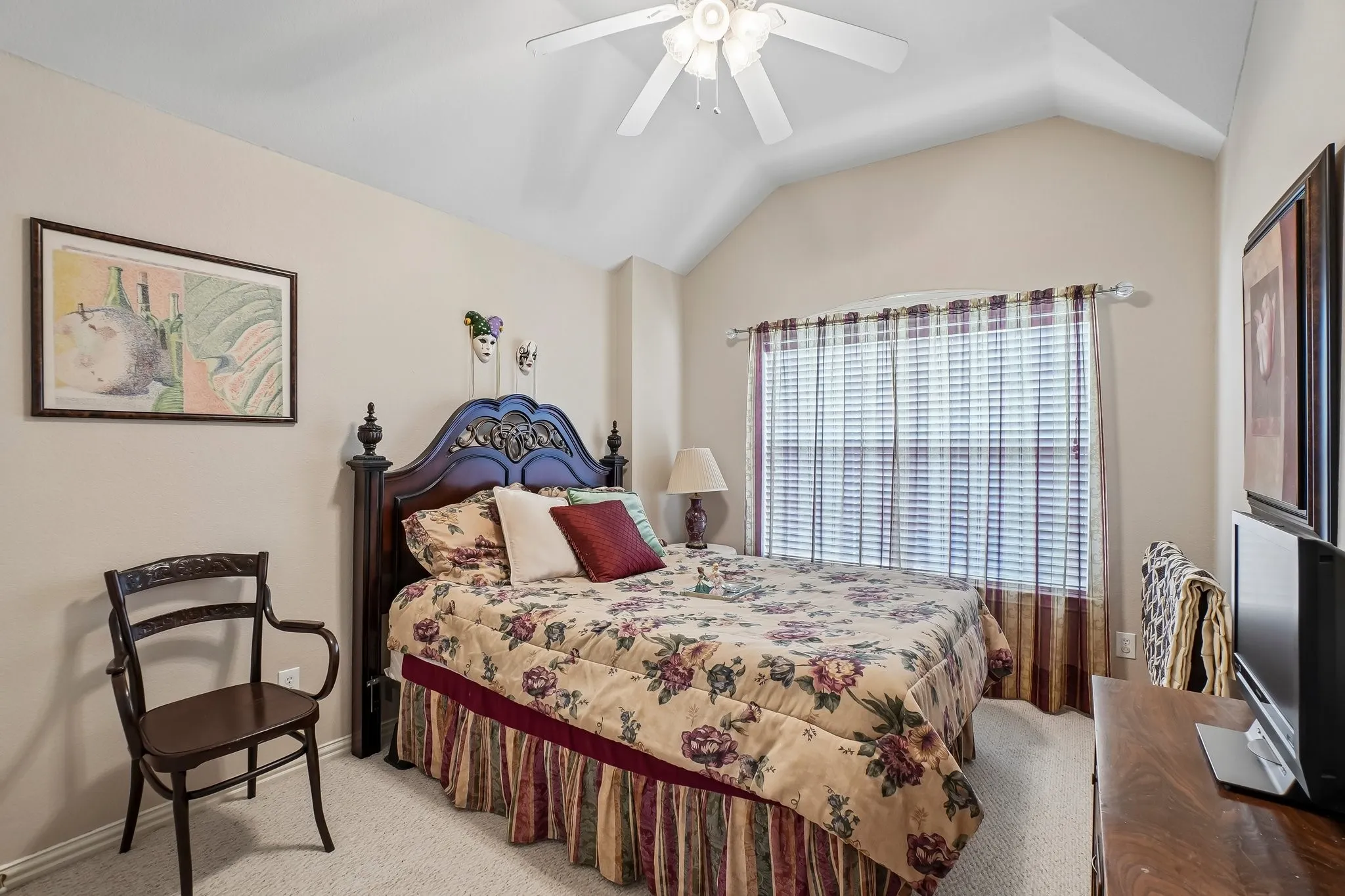 Vaulted ceiling with a ceiling fan, window with blinds and valance, and carpeted flooring