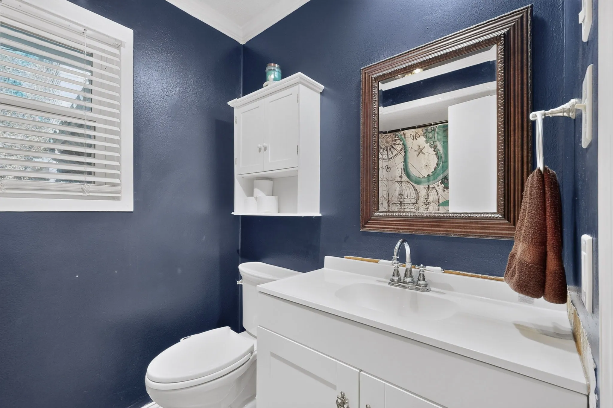 White vanity with integrated sink, chrome faucet, and white countertop