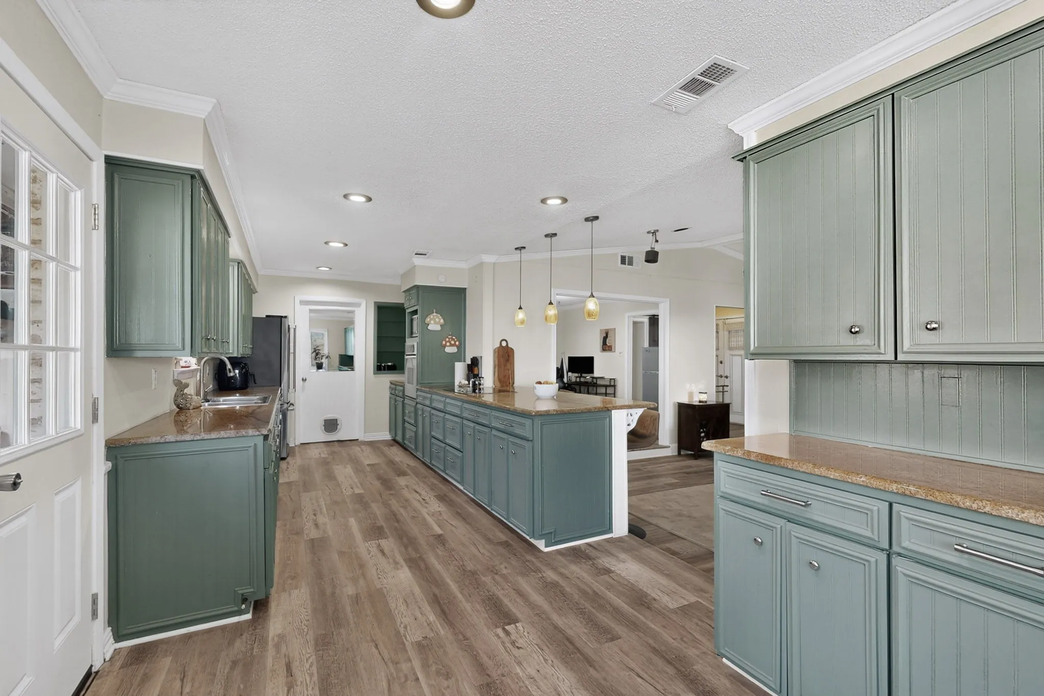 Kitchen featuring green cabinetry, granite countertops, wood-finish flooring, and recessed lighting