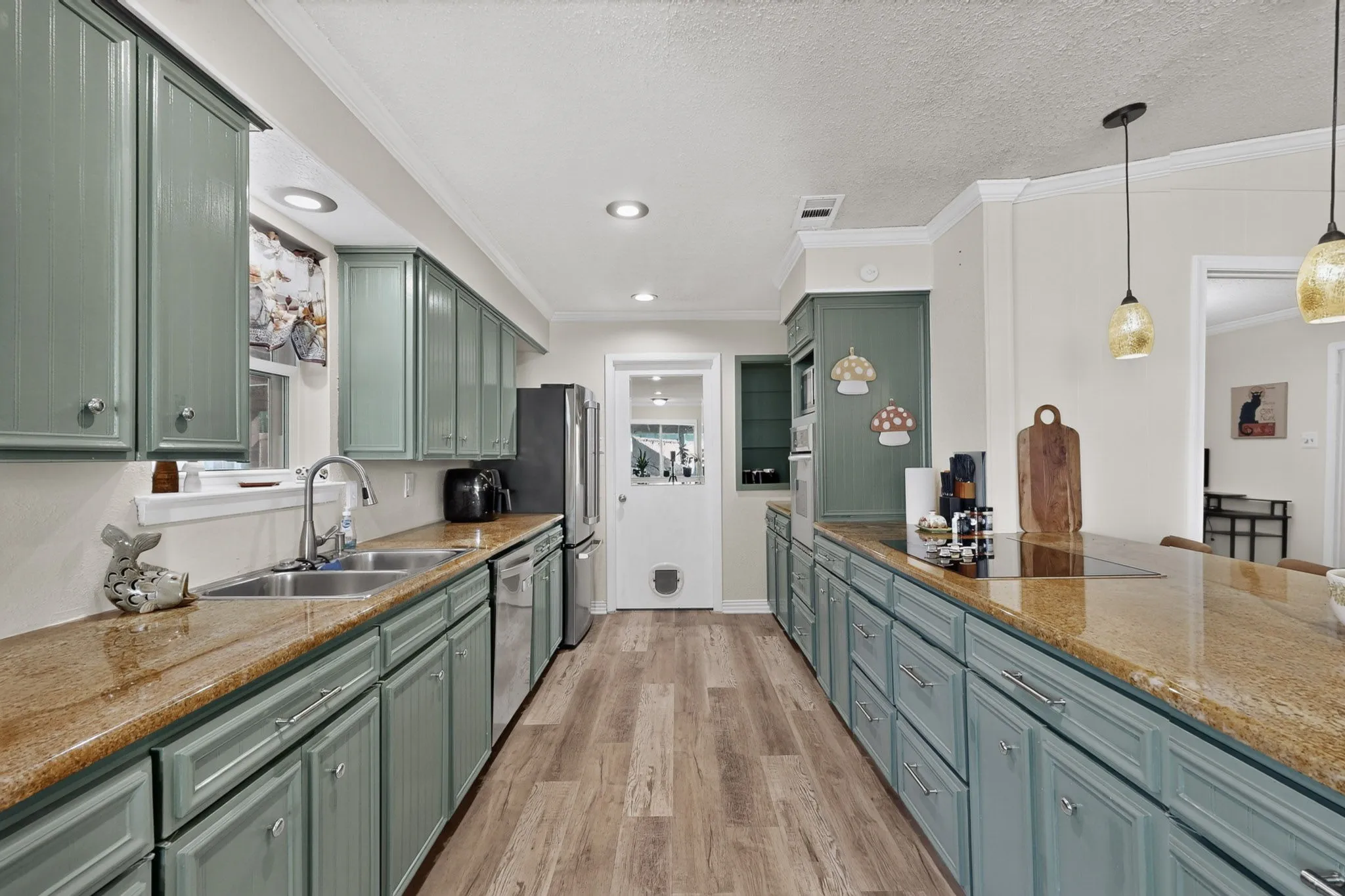 Spacious kitchen featuring extensive cabinetry, stone-finish countertops, wood-finish flooring, and recessed lighting