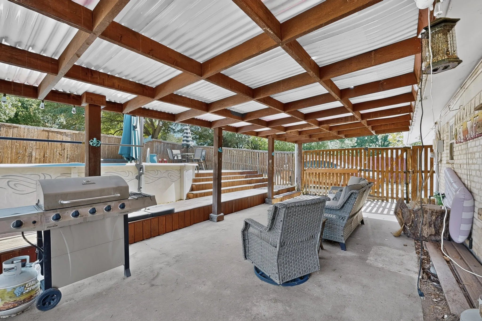 Covered patio with a corrugated roof and exposed wood beams