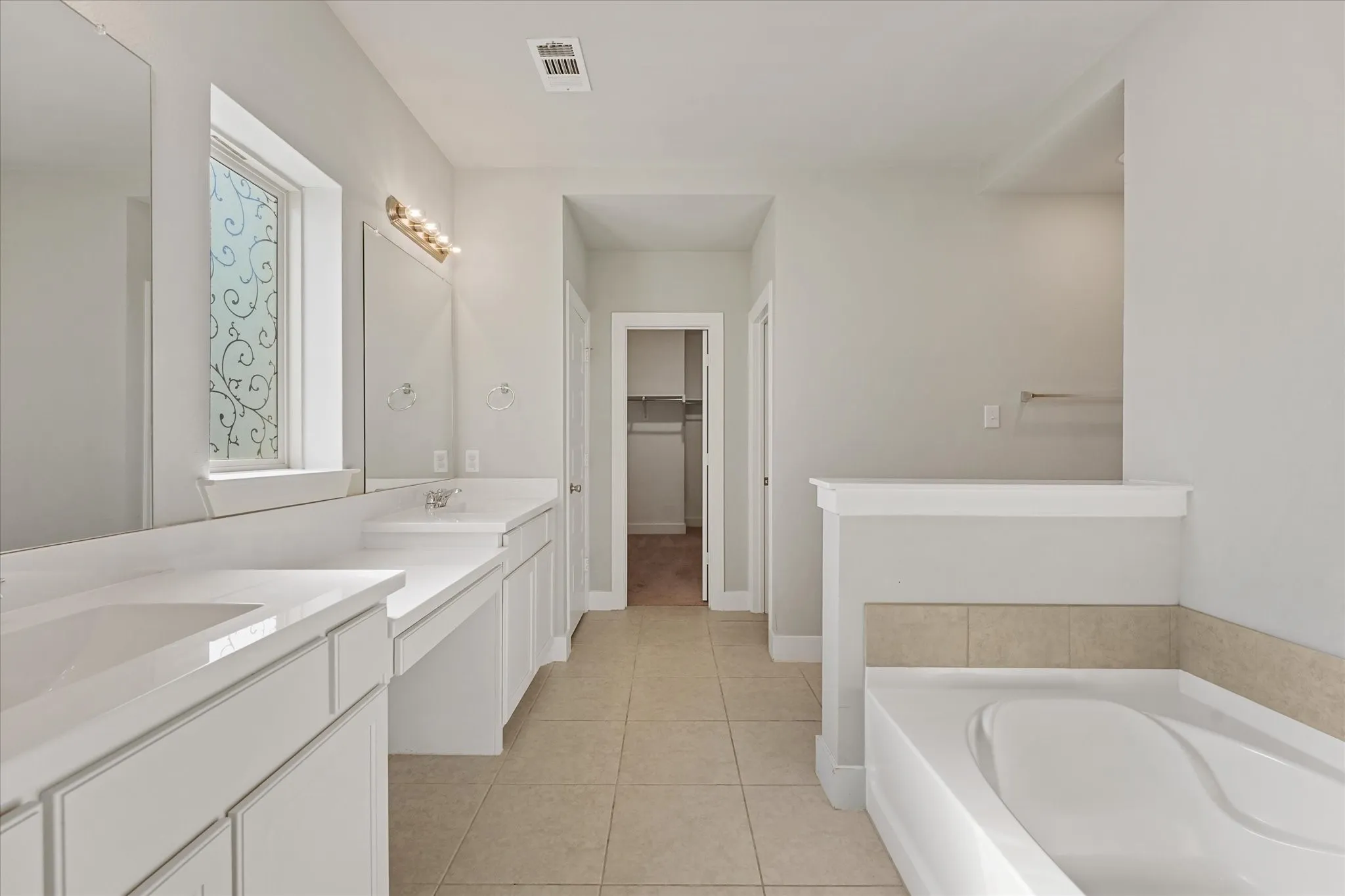 Dual vanity with integrated sinks, ample countertop space, and a built-in makeup area