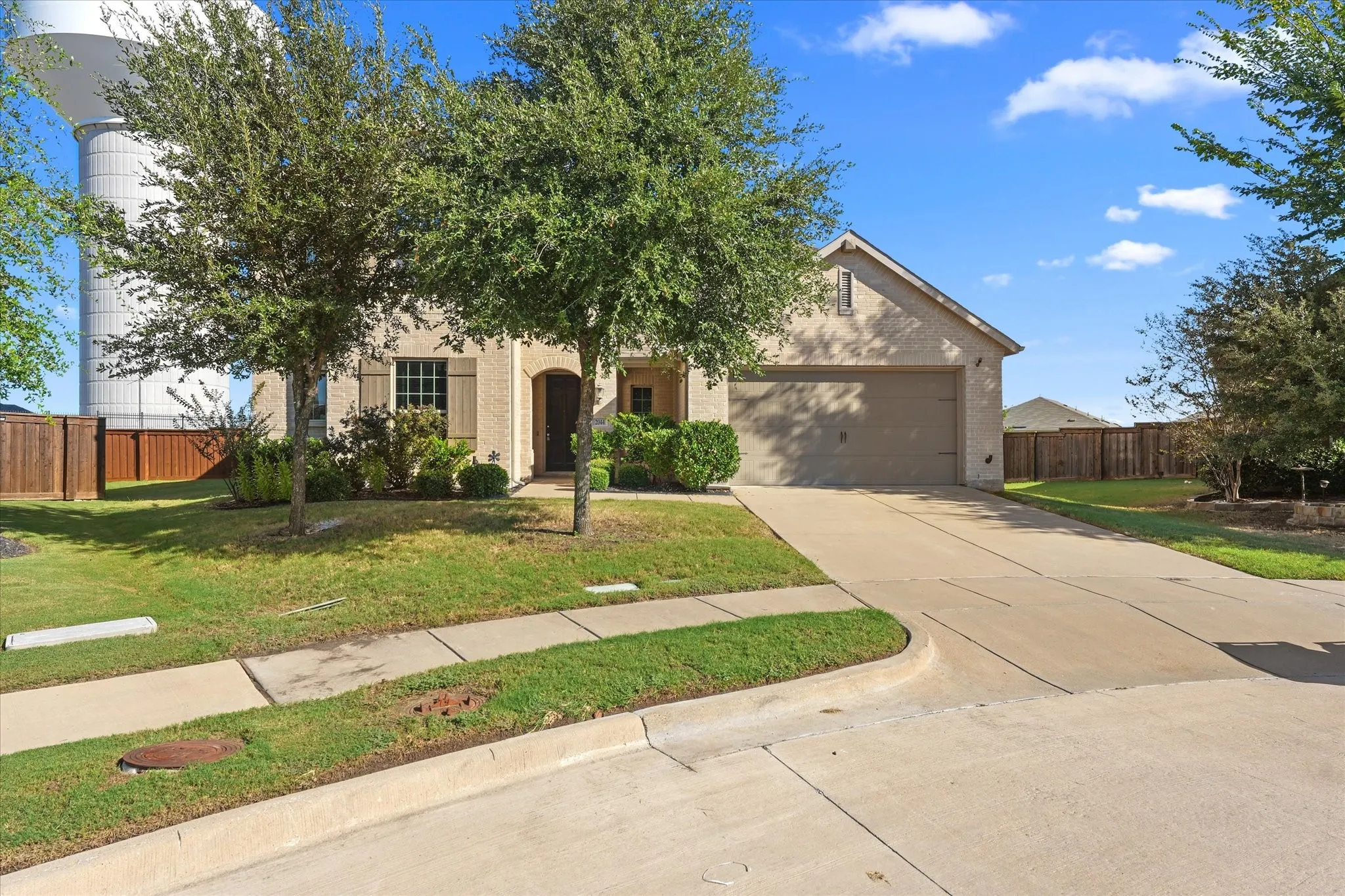 Single-story exterior with a brick and siding facade, an attached two-car garage, and a concrete driveway