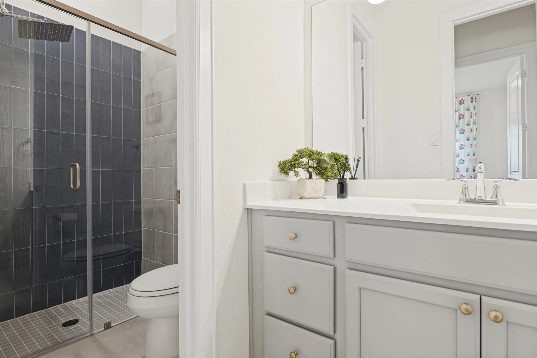 Walk-in shower with dark tile surround and glass enclosure