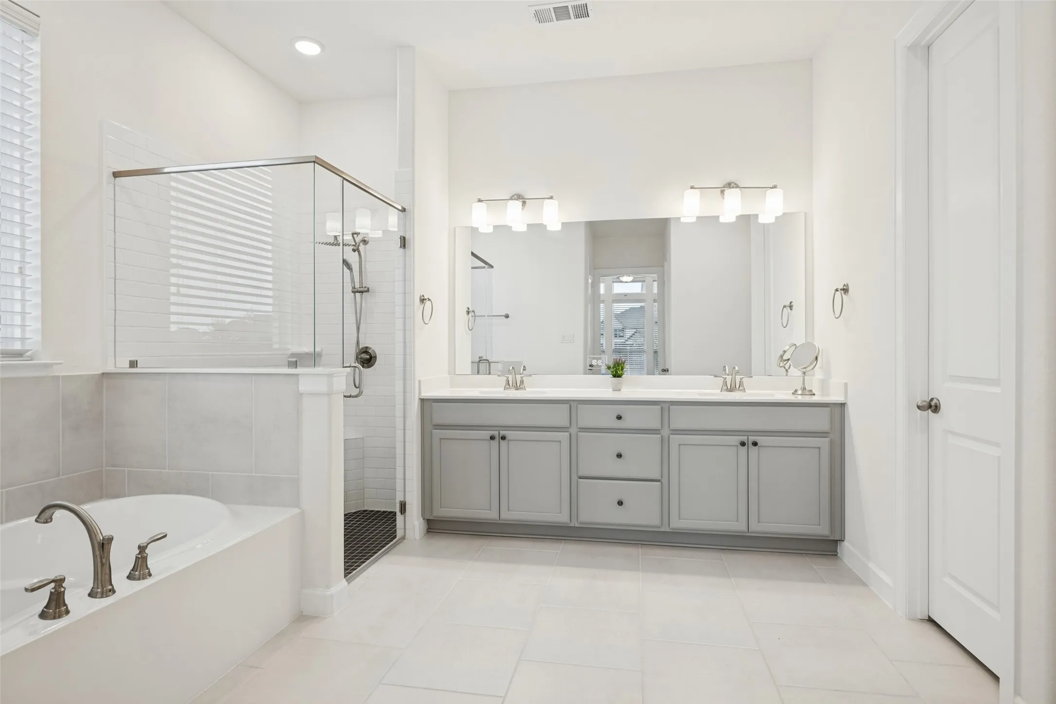 Dual vanity with integrated sinks, brushed nickel fixtures, and light grey cabinetry