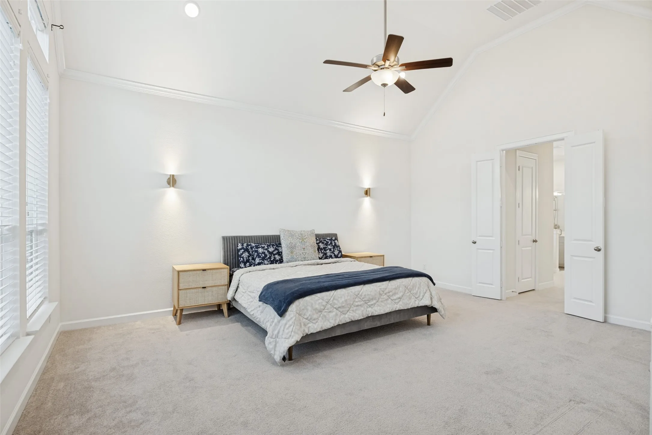 Vaulted ceiling, ceiling fan, recessed lighting, wall sconces, carpet flooring