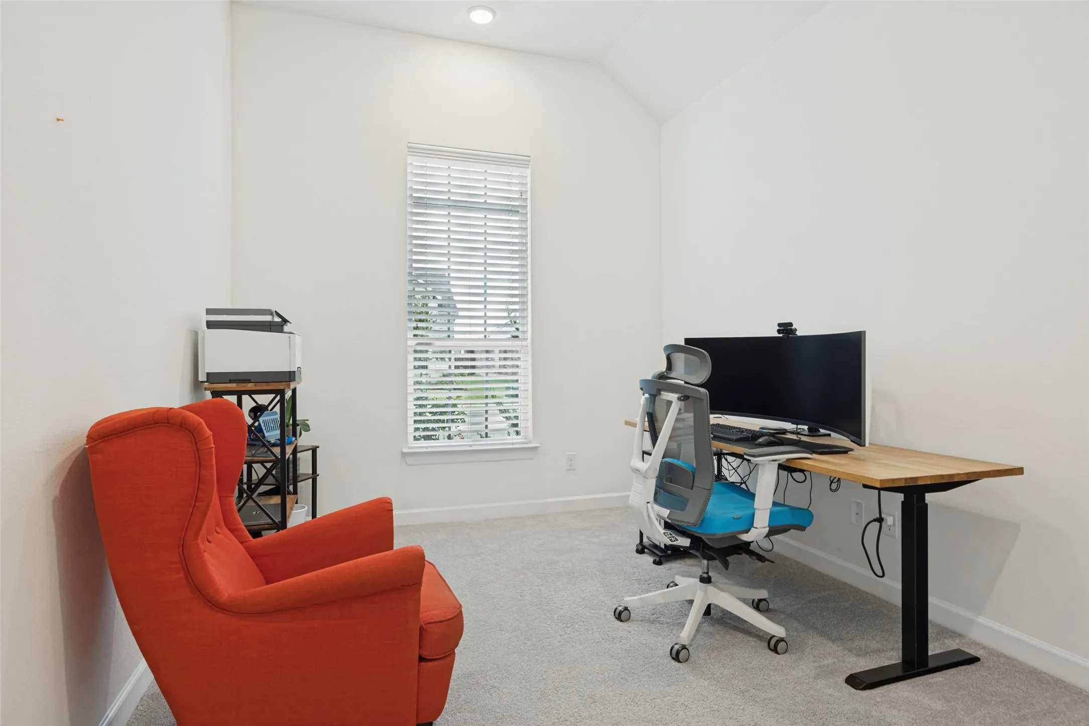 Vaulted ceiling, recessed lighting, window with blinds, light-toned carpeting
