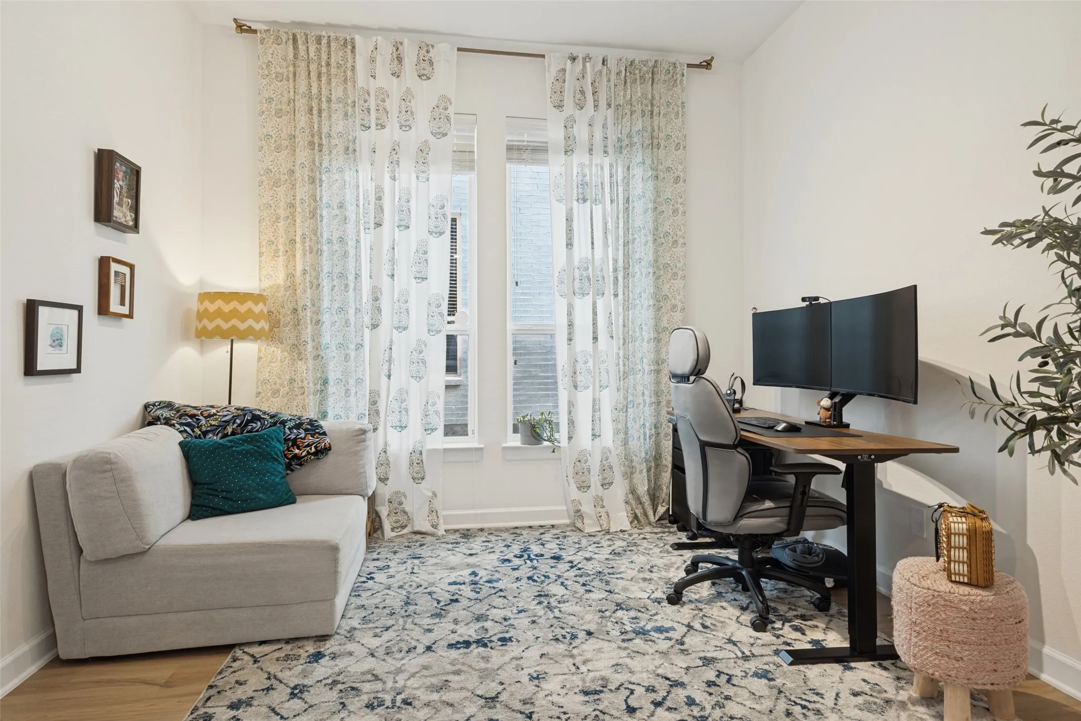 Wood-finish flooring with white baseboards, featuring a window and a large white wall