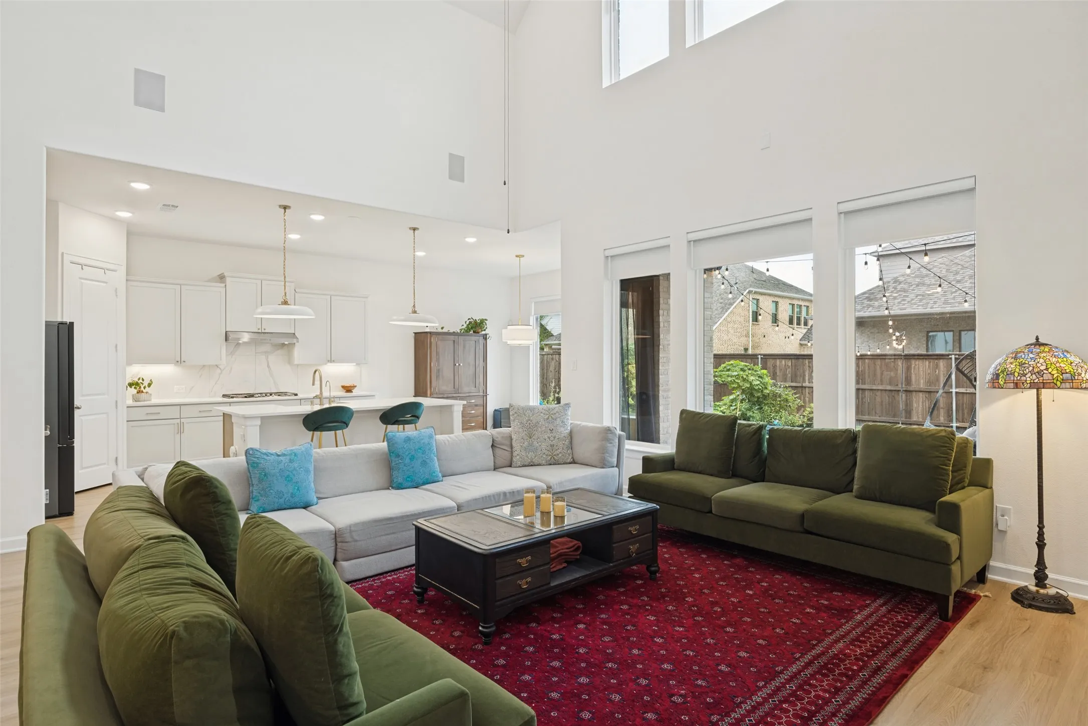 Open-concept living area with soaring ceilings, recessed lighting, and wood-finish flooring