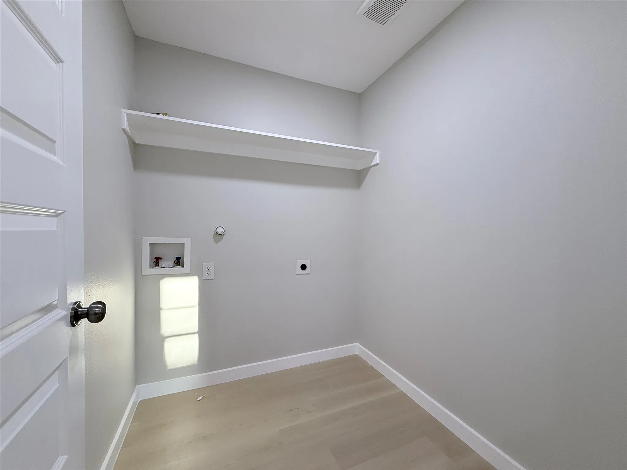 Utility connections, built-in shelving, and wood-finish flooring