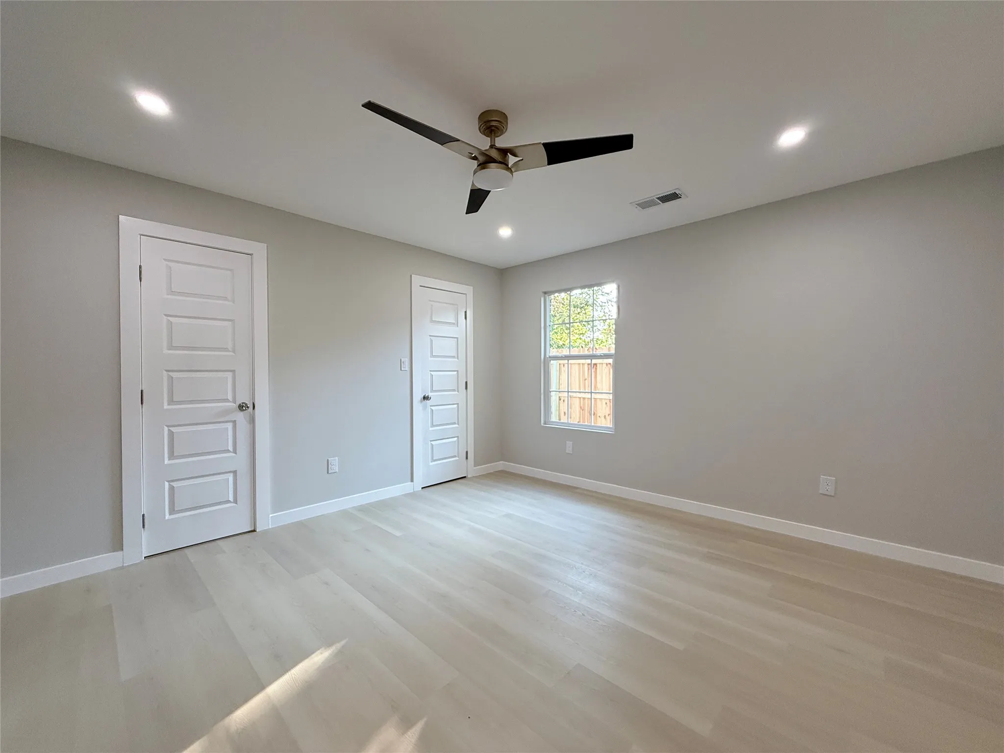 Light-toned wood-finish flooring complements the neutral wall color