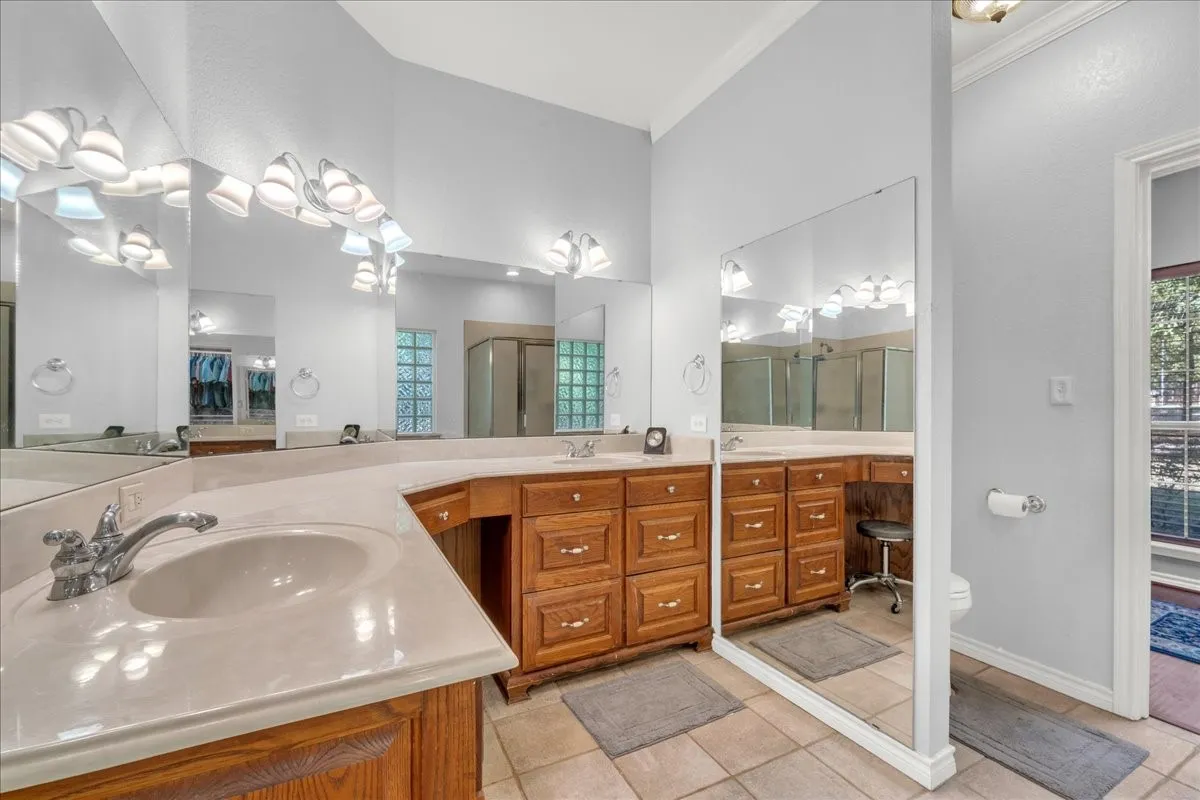 Dual vanity with undermount sinks, light-toned countertops, and wood cabinetry
