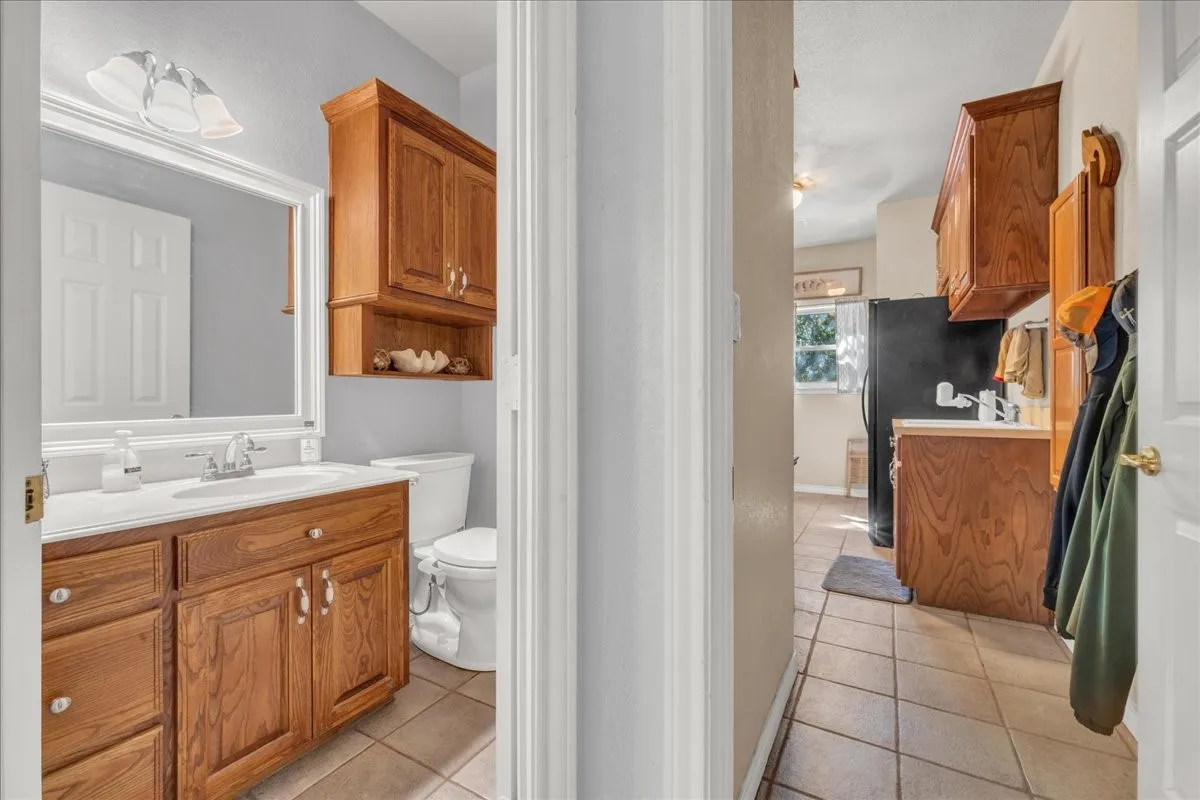 Bathroom featuring a vanity with wood-finish cabinetry, white countertop, and framed mirror