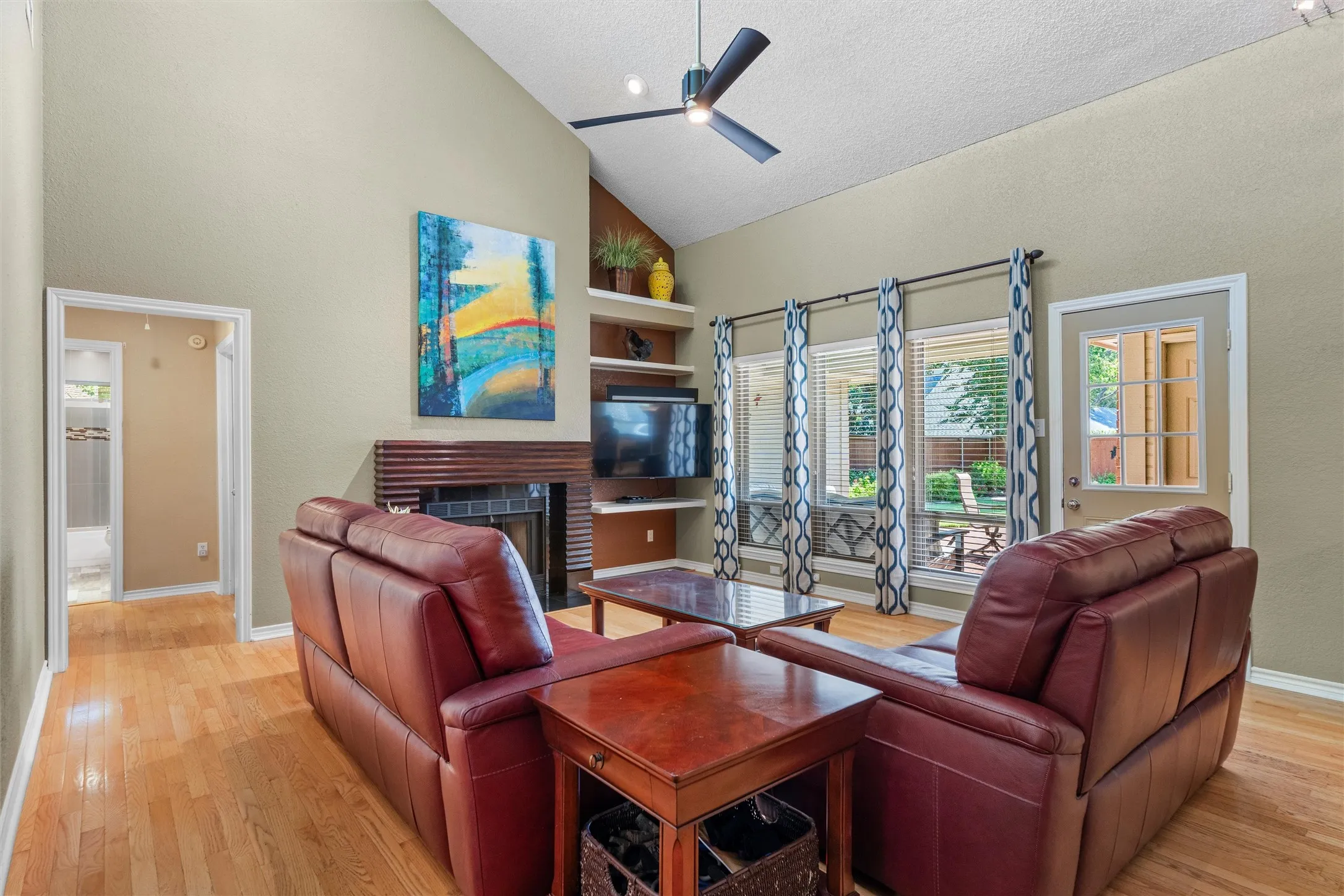 Large picture windows bring the light in and show off the backyard. Gas log fireplace with custom designed solid wood mantel surround.