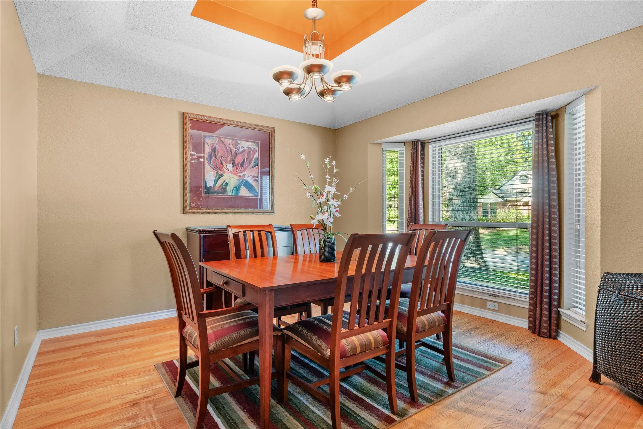 Dining area with recessed ceiling large picture window at the front of the house.