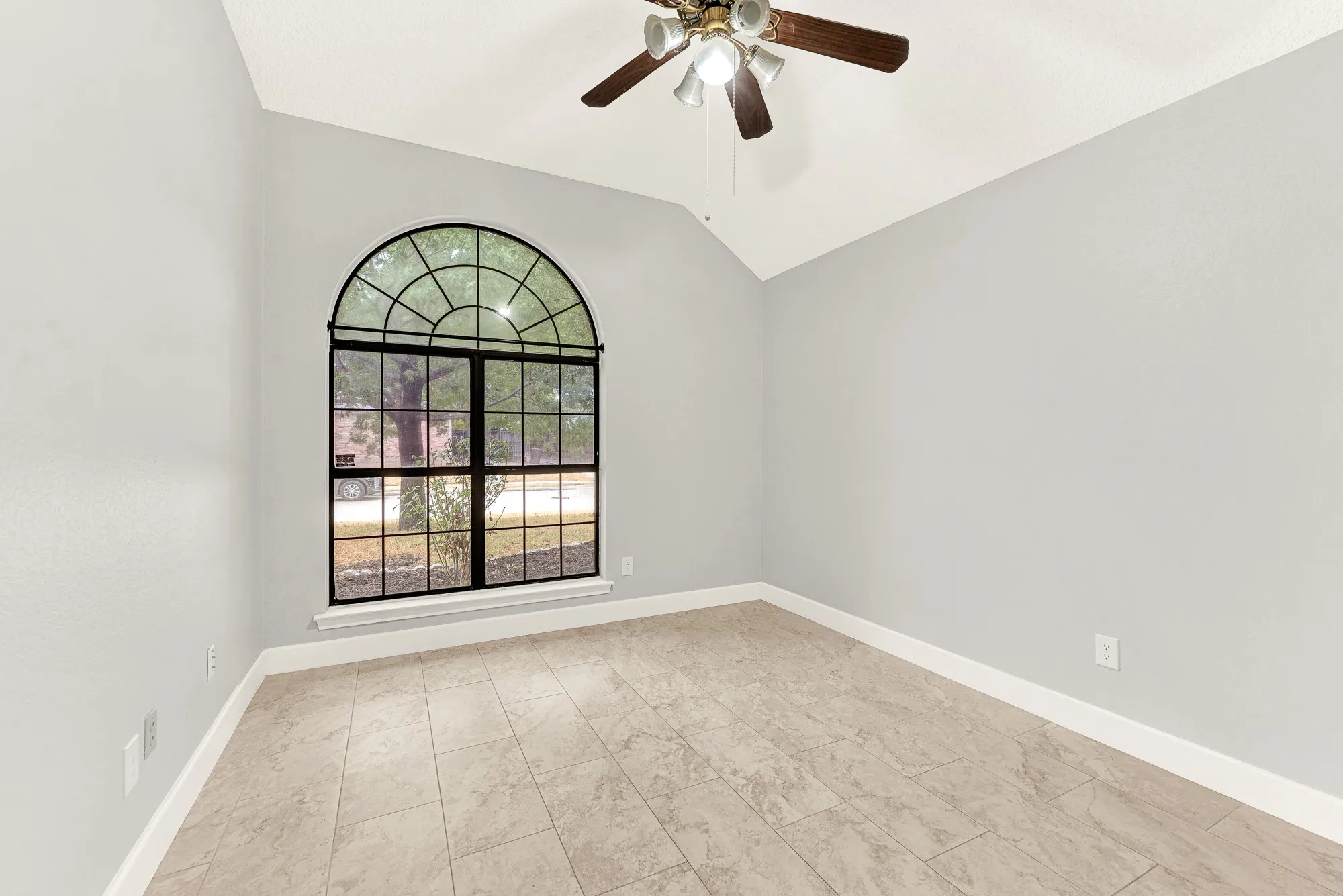 High vaulted lines draw the eyes upward while black window mullions frame serene outdoor greenery. Picture turning this quiet space into a creative home studio or peaceful nursery filled with soft morning light.