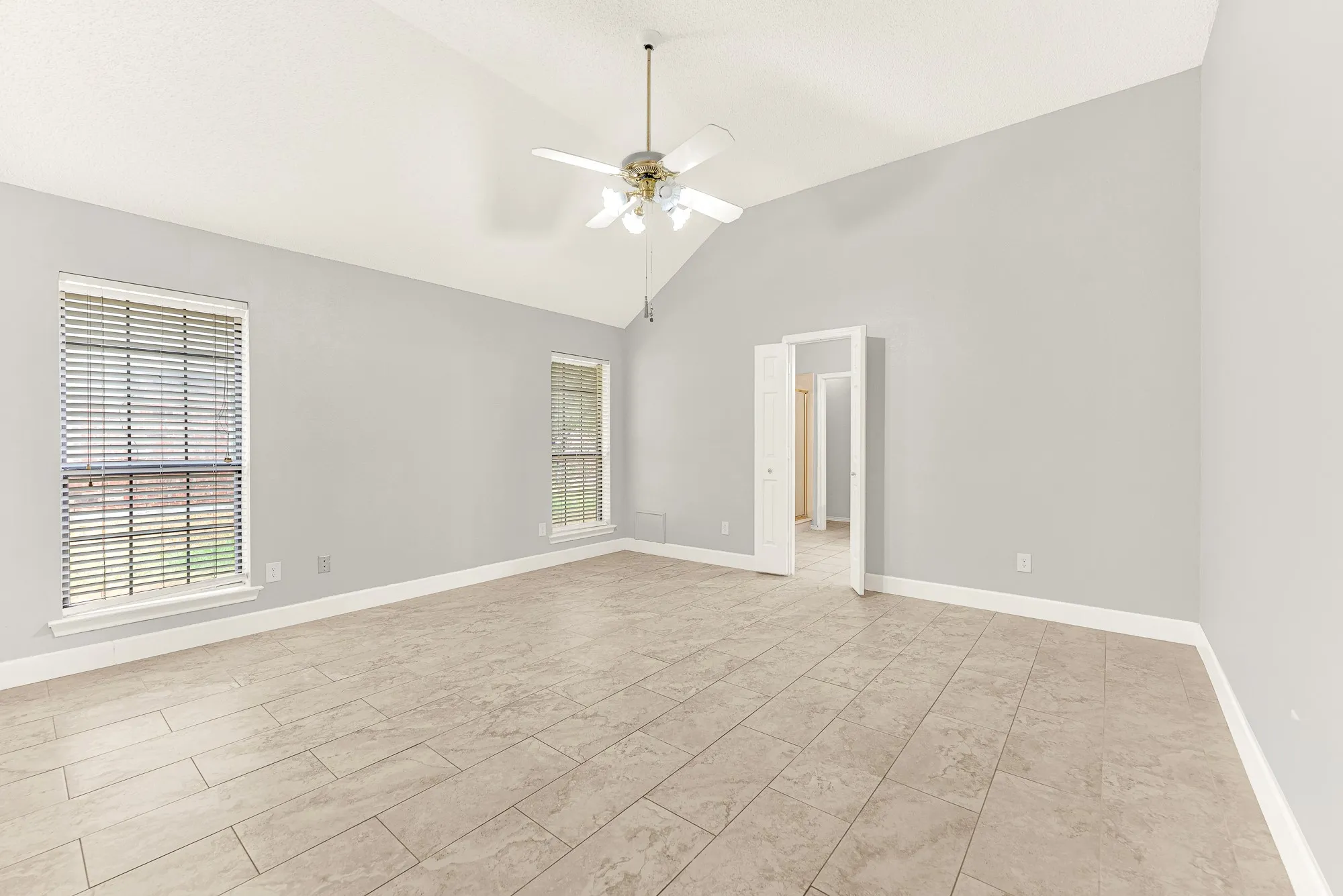 A dramatic vaulted ceiling rises above smooth tile floors, giving this spacious retreat a light and airy dimension. Picture waking up to soft morning rays filtering through double windows as you begin your day.