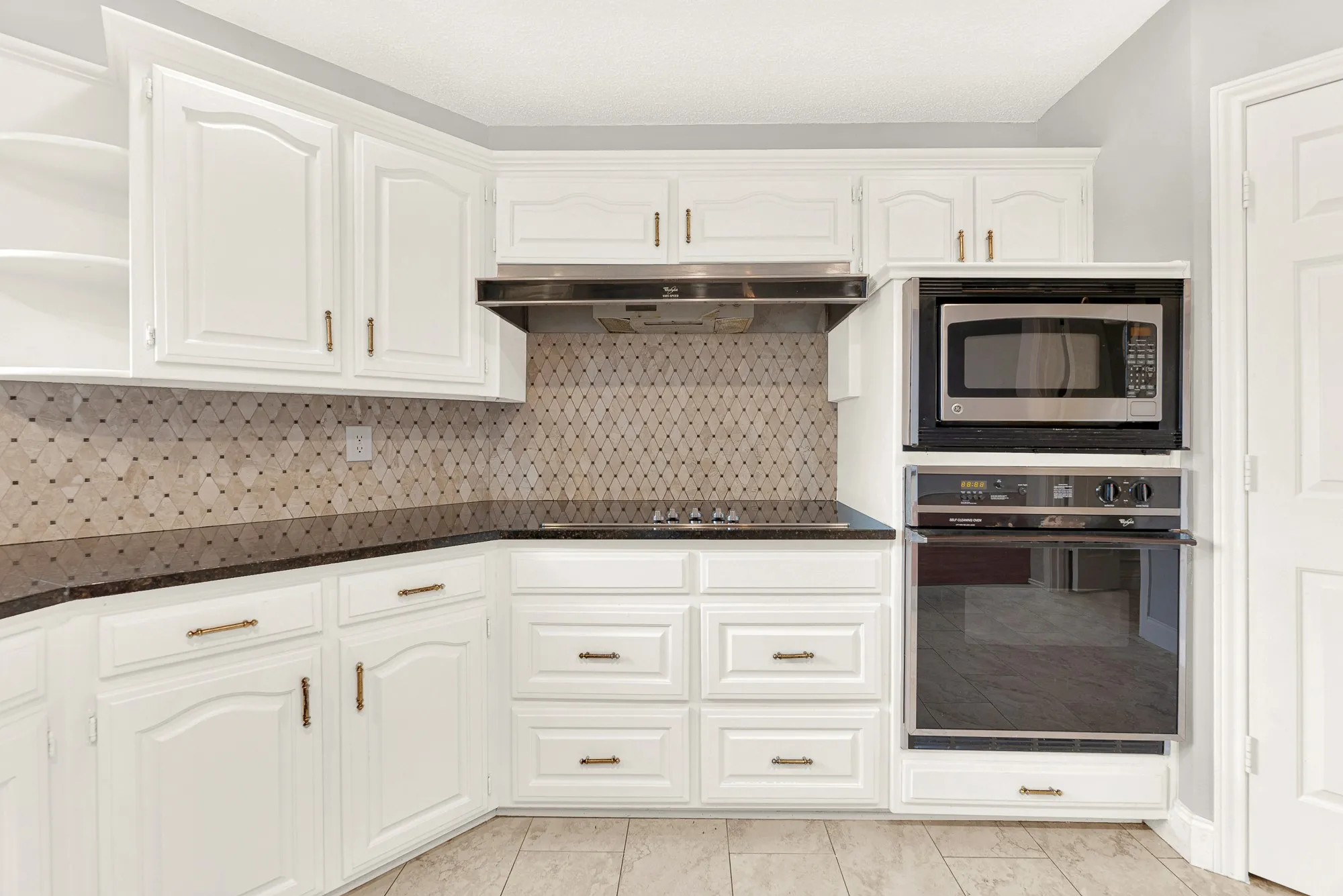 Built-in double wall ovens anchor a clean, symmetrical workstation designed for effortless meal preparation. You can easily picture roasting a festive dinner while enjoying a stress-free cooking experience.
