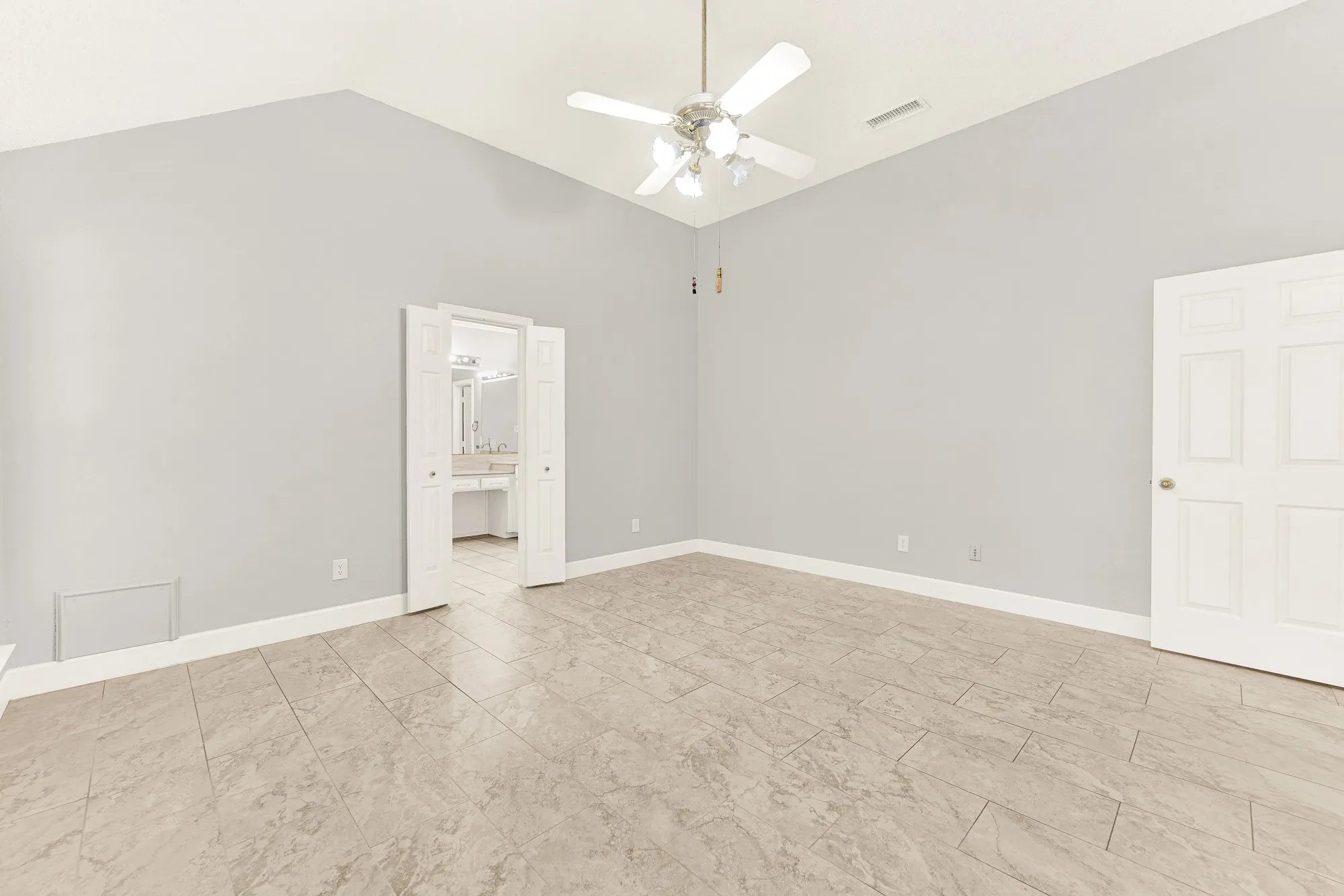 Double entry doors open seamlessly into the main bedroom, connecting high ceilings with effortless interior flow. You can easily picture slipping into comfortable loungewear after a long day in this tranquil space.
