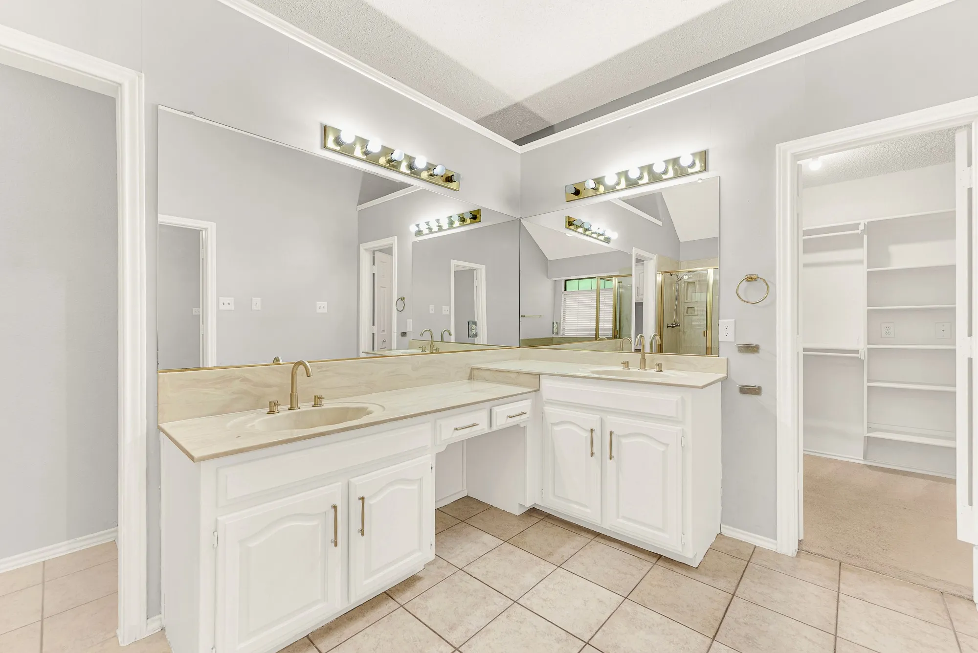 An L-shaped double vanity offers generous counter space while connecting directly to a spacious walk-in closet. Imagine easily selecting your daily outfit from the organized storage just steps away.