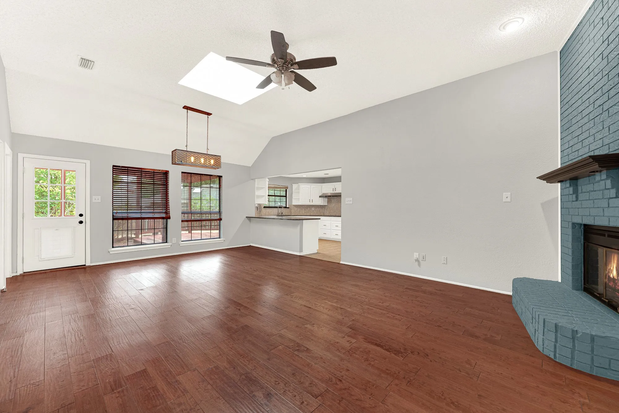 A painted brick fireplace commands attention, providing a colorful focal point against light grey walls. Imagine cozying up with a warm tea on chilly winter nights, enjoying the soothing glow of a flickering fire.