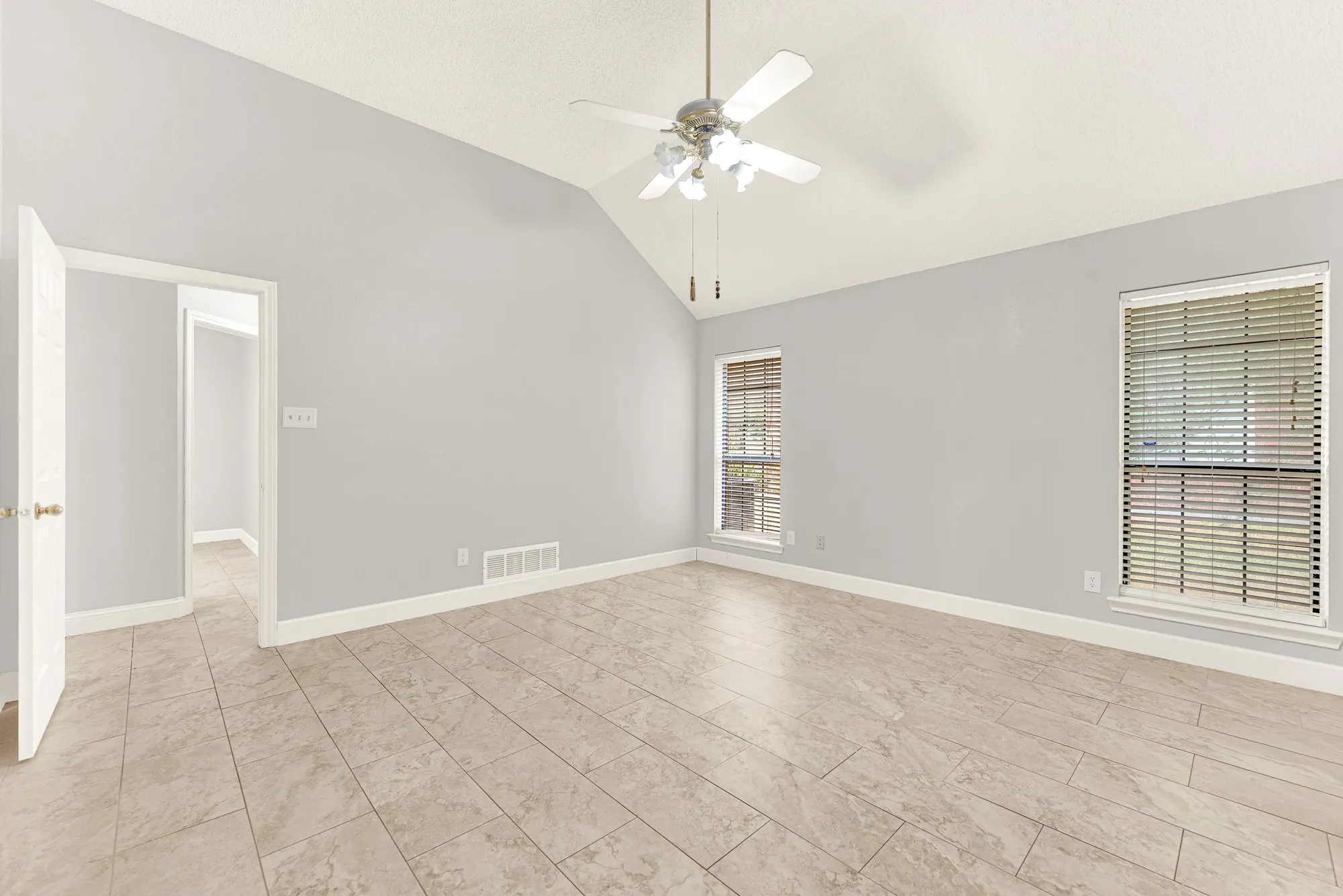 Clean neutral walls surround wide sightlines, enhancing the room's peaceful architectural symmetry. Imagine curling up with your favorite book in a cozy corner armchair during a quiet evening reset.