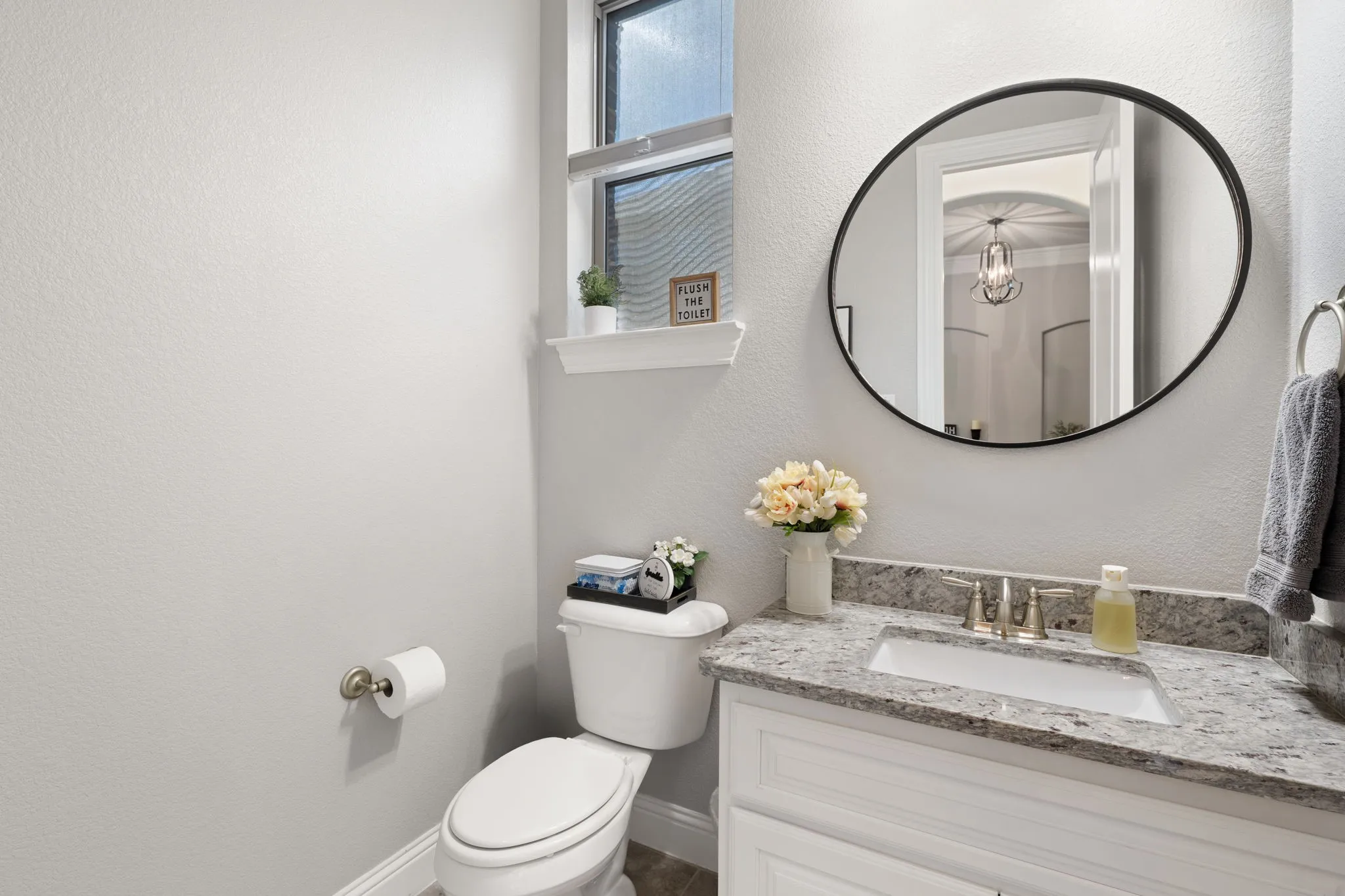 Vanity with a granite-style countertop, undermount sink, and brushed nickel faucet