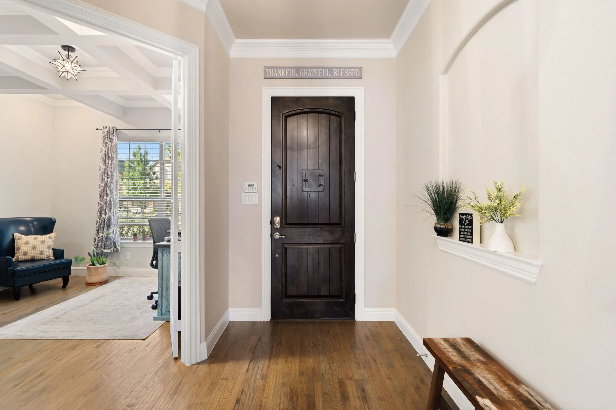Hardwood flooring throughout, a solid wood entry door, and an arched niche with a built-in display shelf