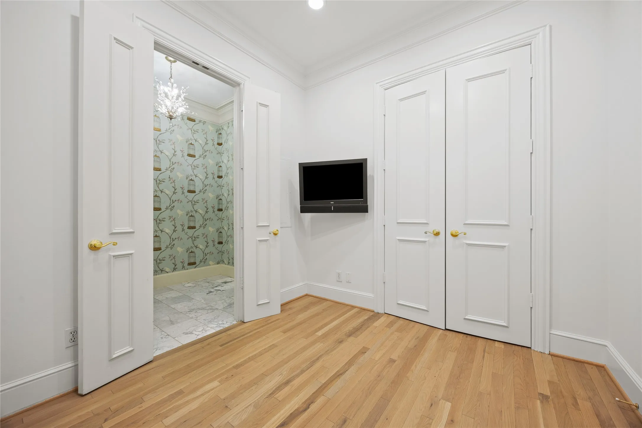 Spacial den, office or guest room featuring french doors and a full closet
