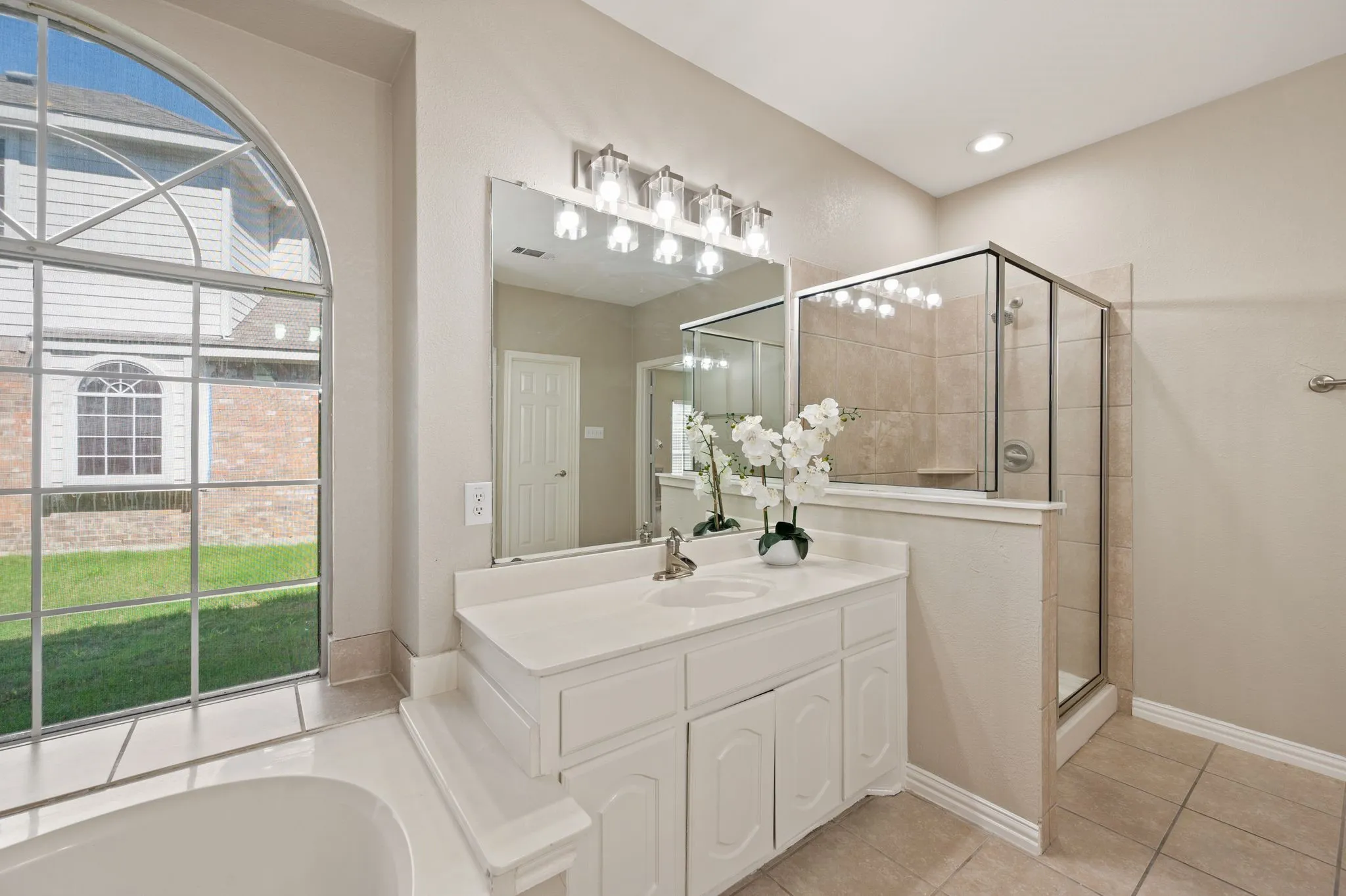 A bright vanity, generous mirror & separate tiled shower make this inviting primary bath a comfortable place to start your day.