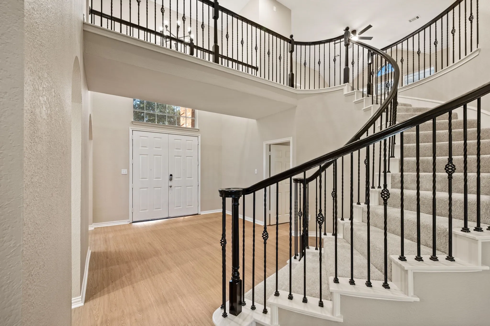 Make a grand entrance! Soaring ceilings, a sweeping curved staircase & decorative iron balusters set the stage for this inviting home.