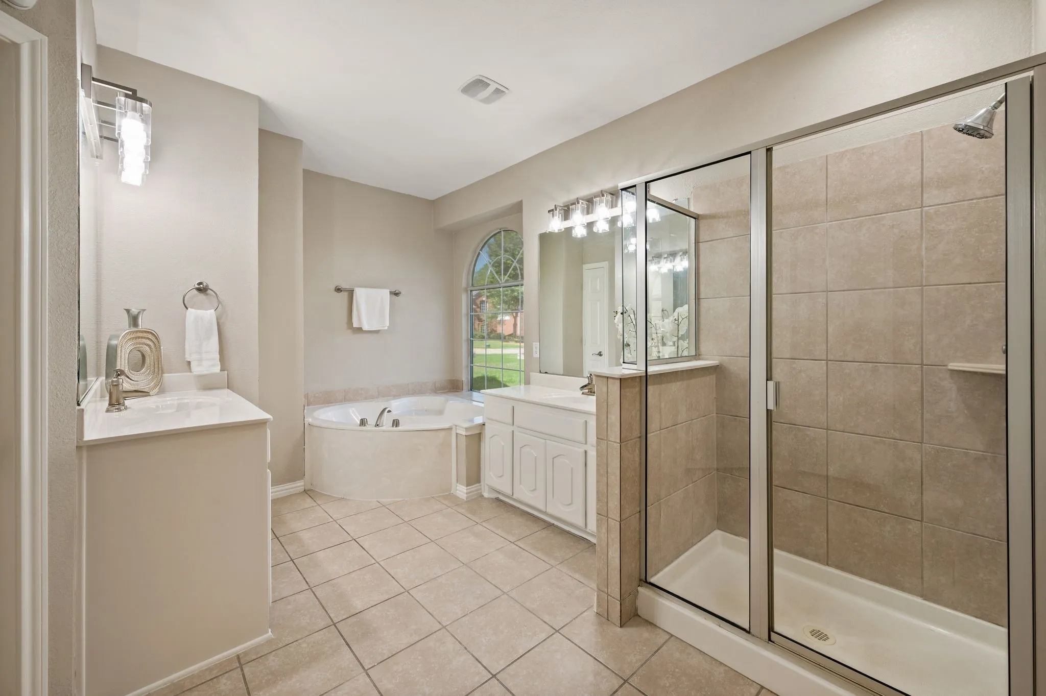Unwind in the primary bath with a relaxing soaking tub, separate glass-enclosed shower & two vanity areas.