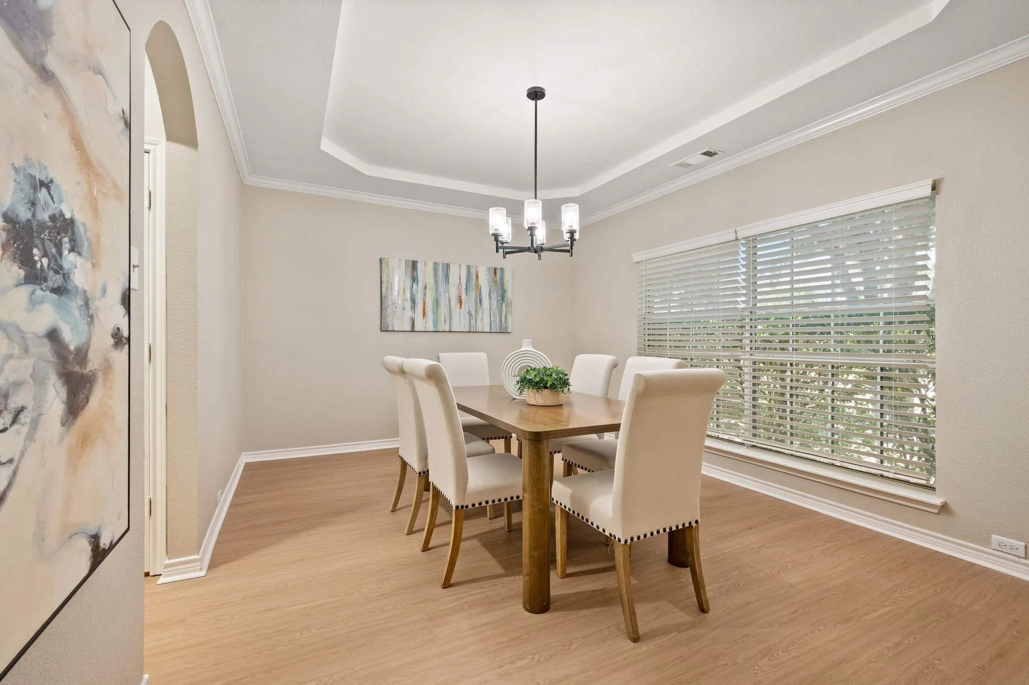 Gather in style in the elegant formal dining room, featuring a tray ceiling, chandelier & generous windows for beautiful natural light.