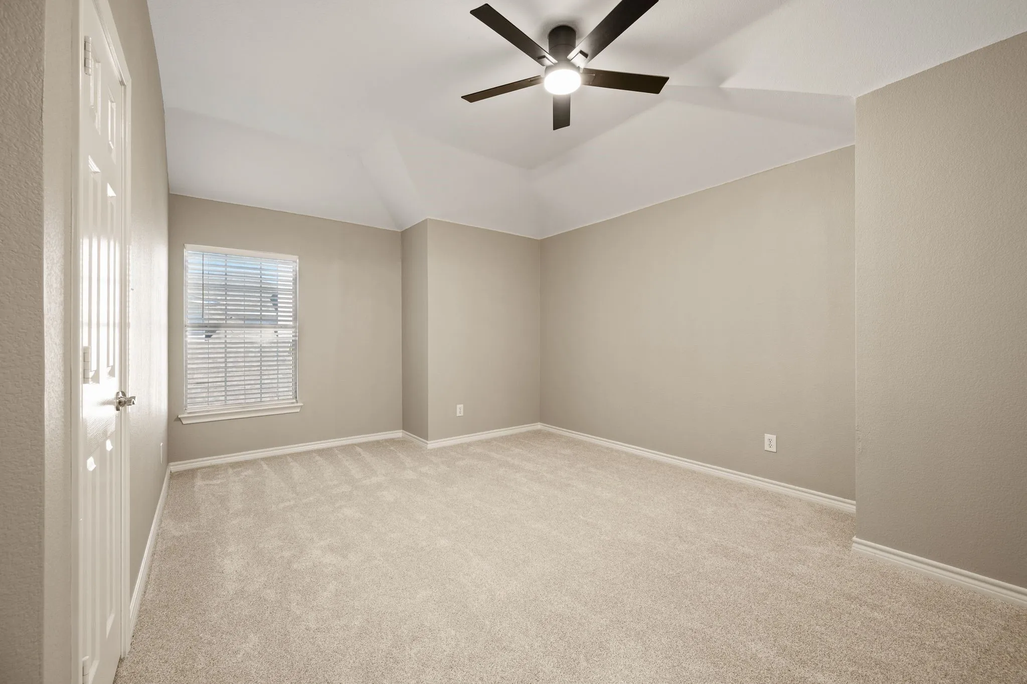 New carpet, a ceiling fan & a walk in closet create a welcoming setting in this spacious secondary bedroom.