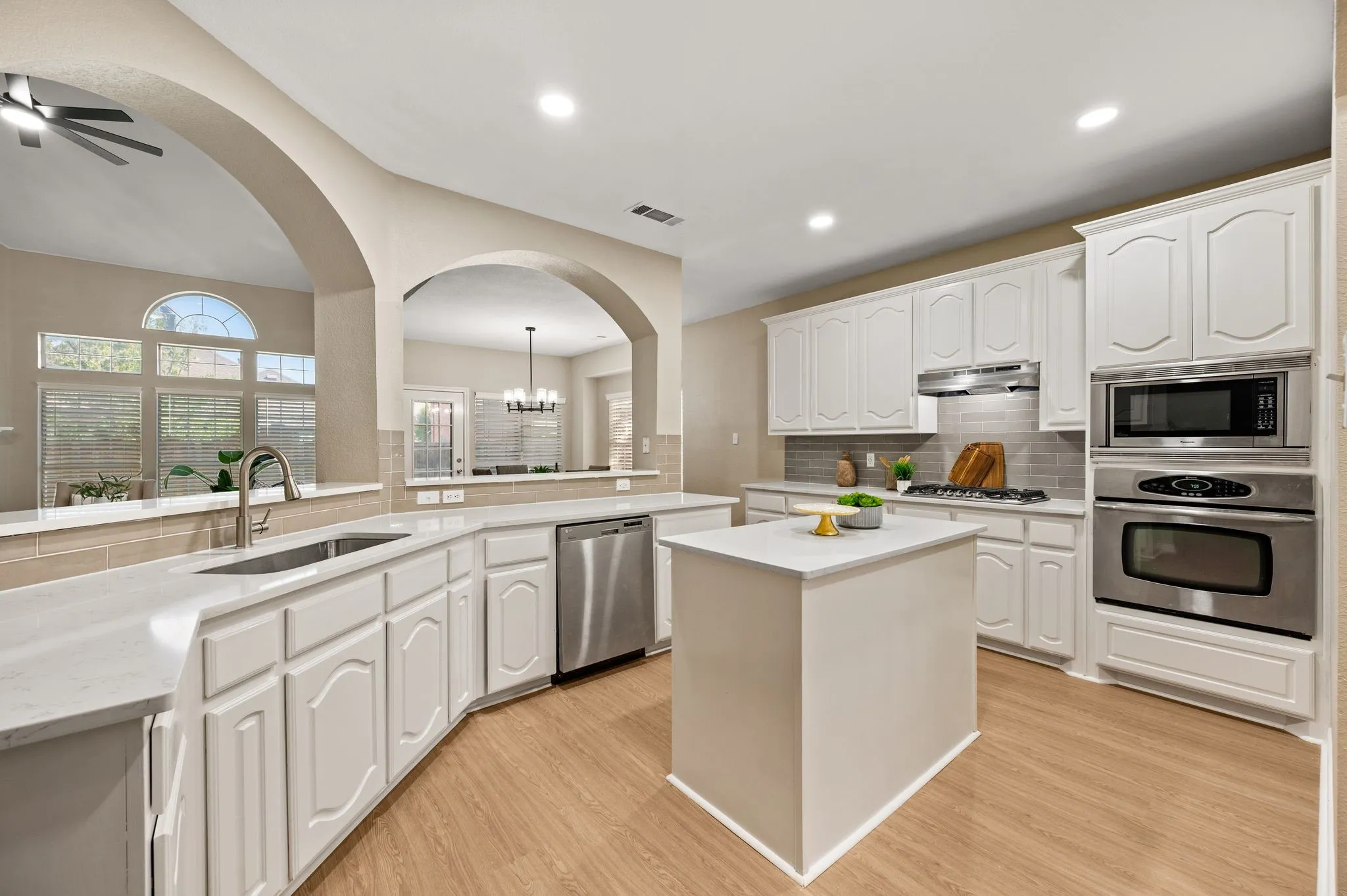This bright kitchen brings everything together with a center island, stainless appliances, generous counter space & a sink overlooking the living area.