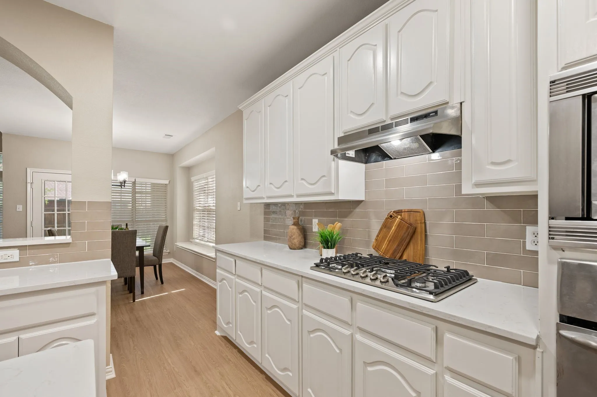 Bring your favorite recipes to life with a gas cooktop, stainless vent hood, tile backsplash & abundant cabinet storage.