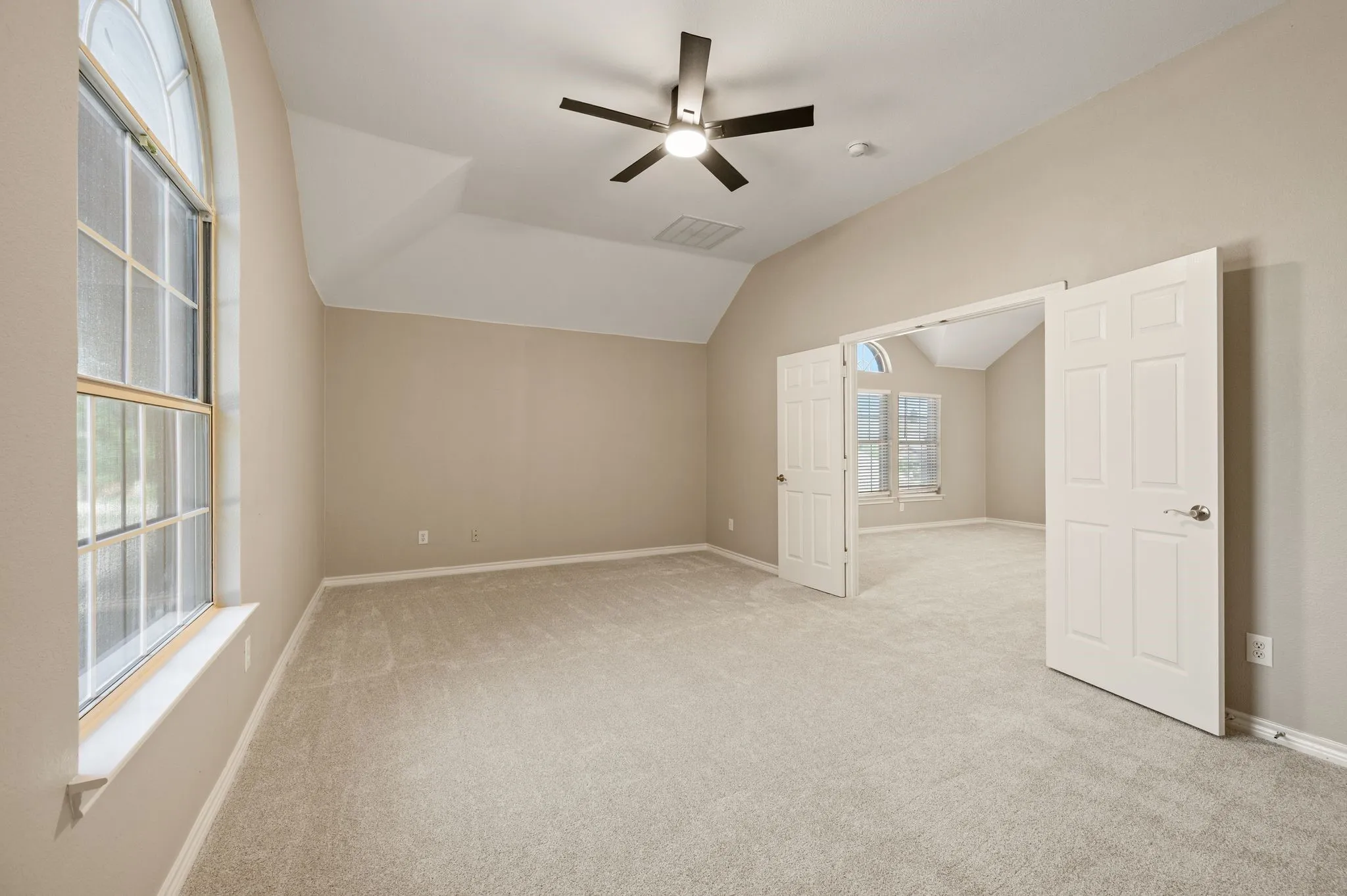Double doors connect this bright, vaulted room to the upstairs living area, offering plenty of possibilities for your lifestyle.