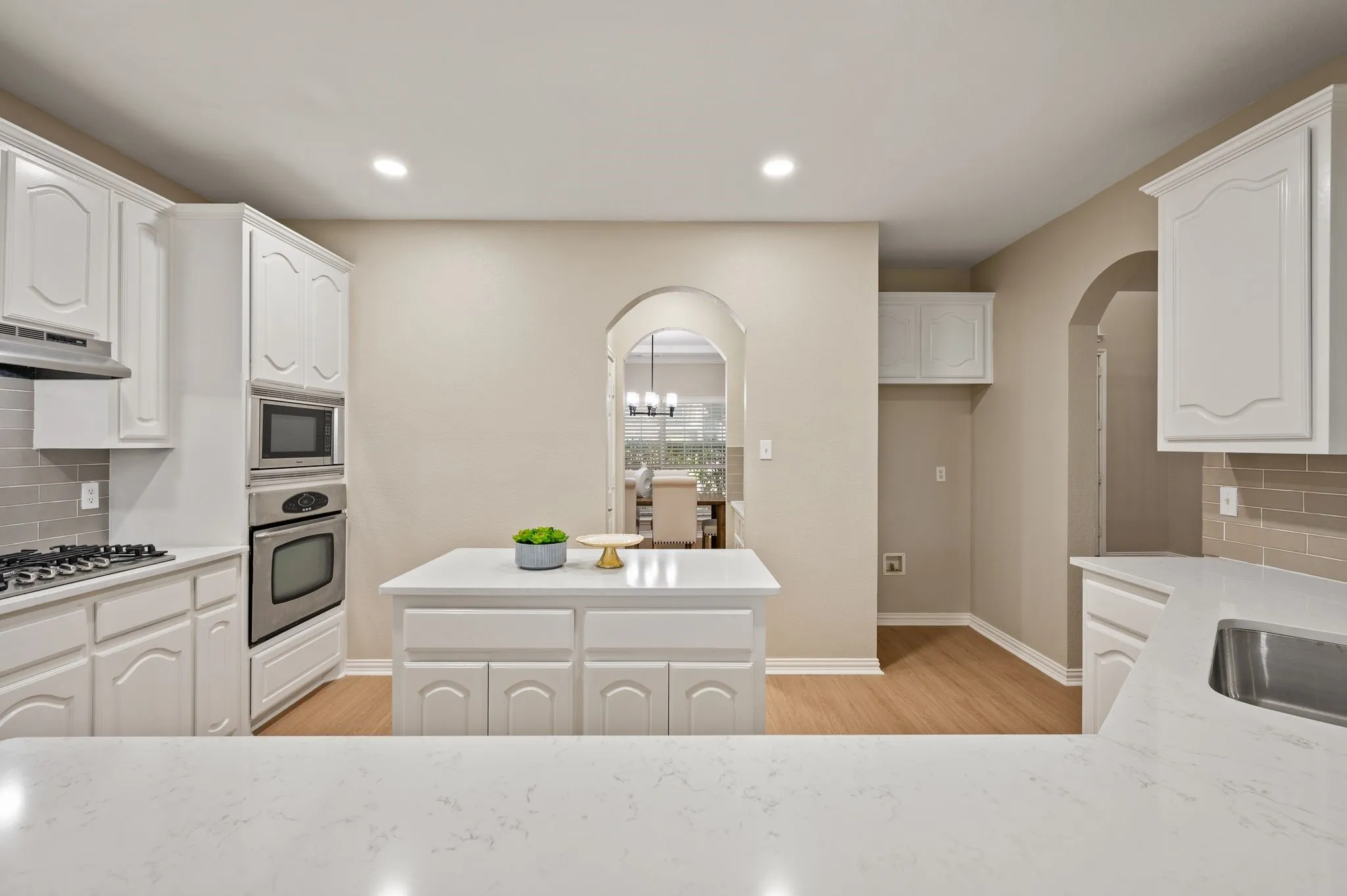 A center island, gas cooktop & built-in appliances create a practical kitchen layout with plenty of room for meal prep. Large walk-in pantry!
