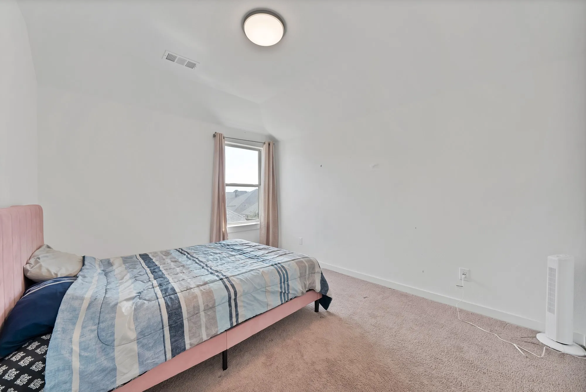 Carpeted flooring, single window, wall outlet, and ceiling-mounted light fixture