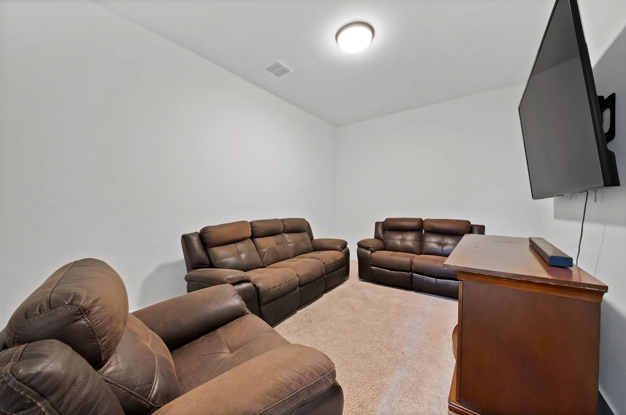 Carpeted flooring, recessed ceiling light, and neutral wall tones