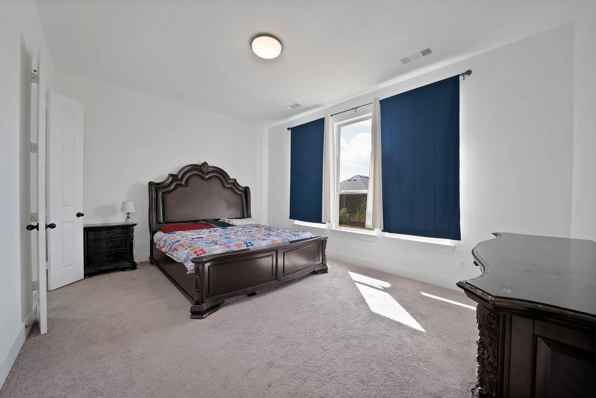 Carpeted room with white walls, two windows, and overhead lighting